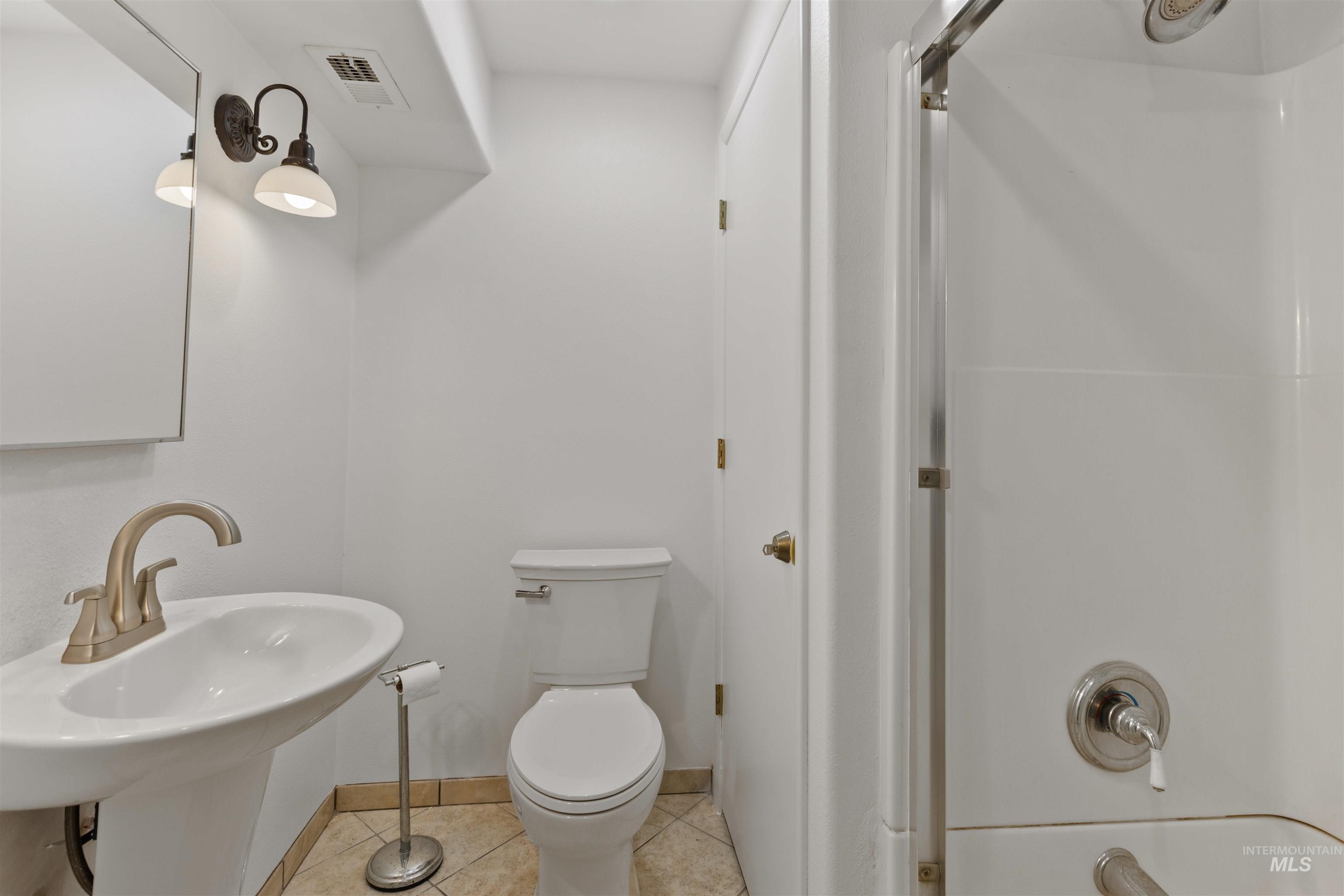 Full bath featuring tile patterned flooring and a sink