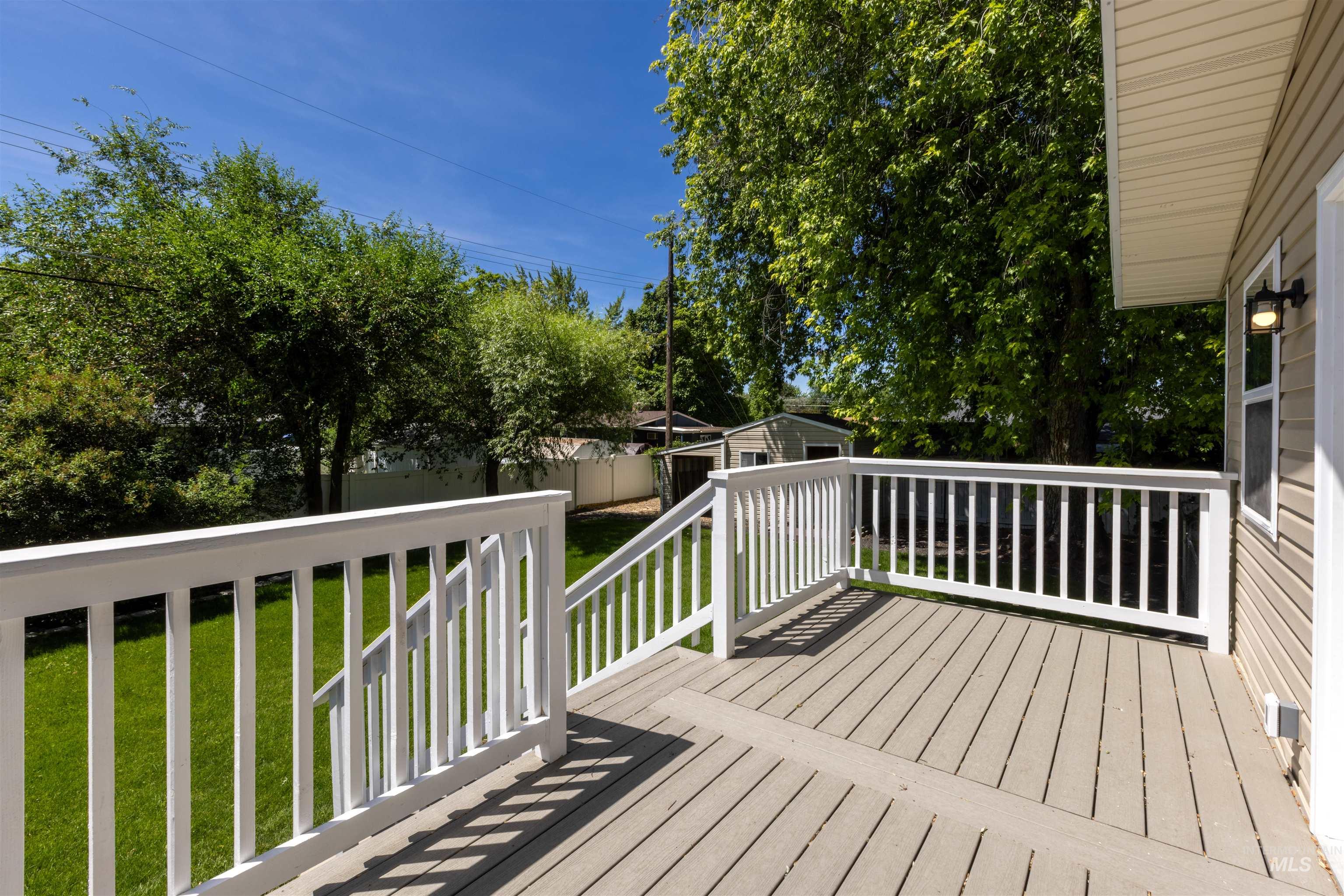 Wooden deck featuring a lawn and an outdoor structure