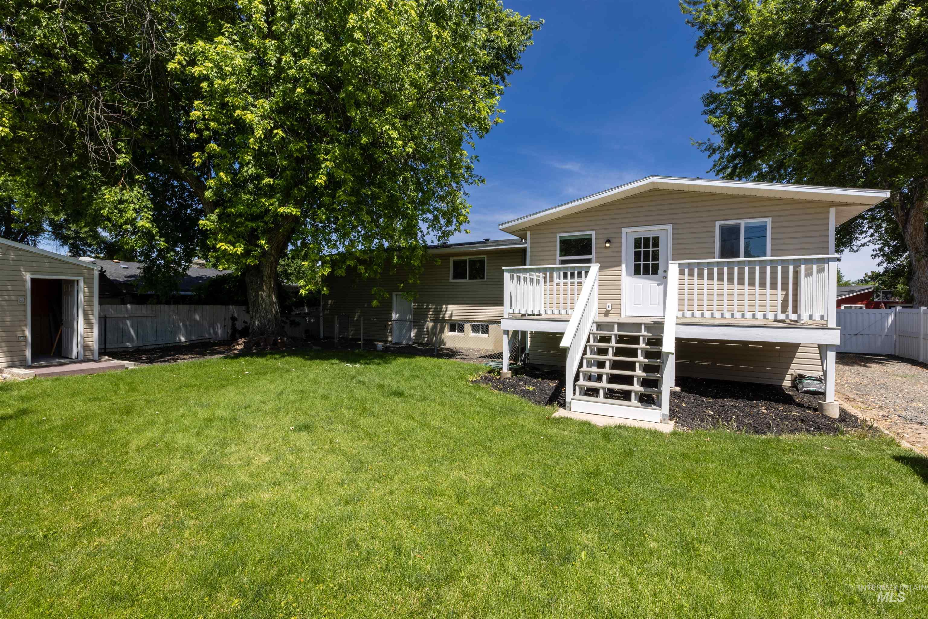 Back of property featuring a fenced backyard and a deck