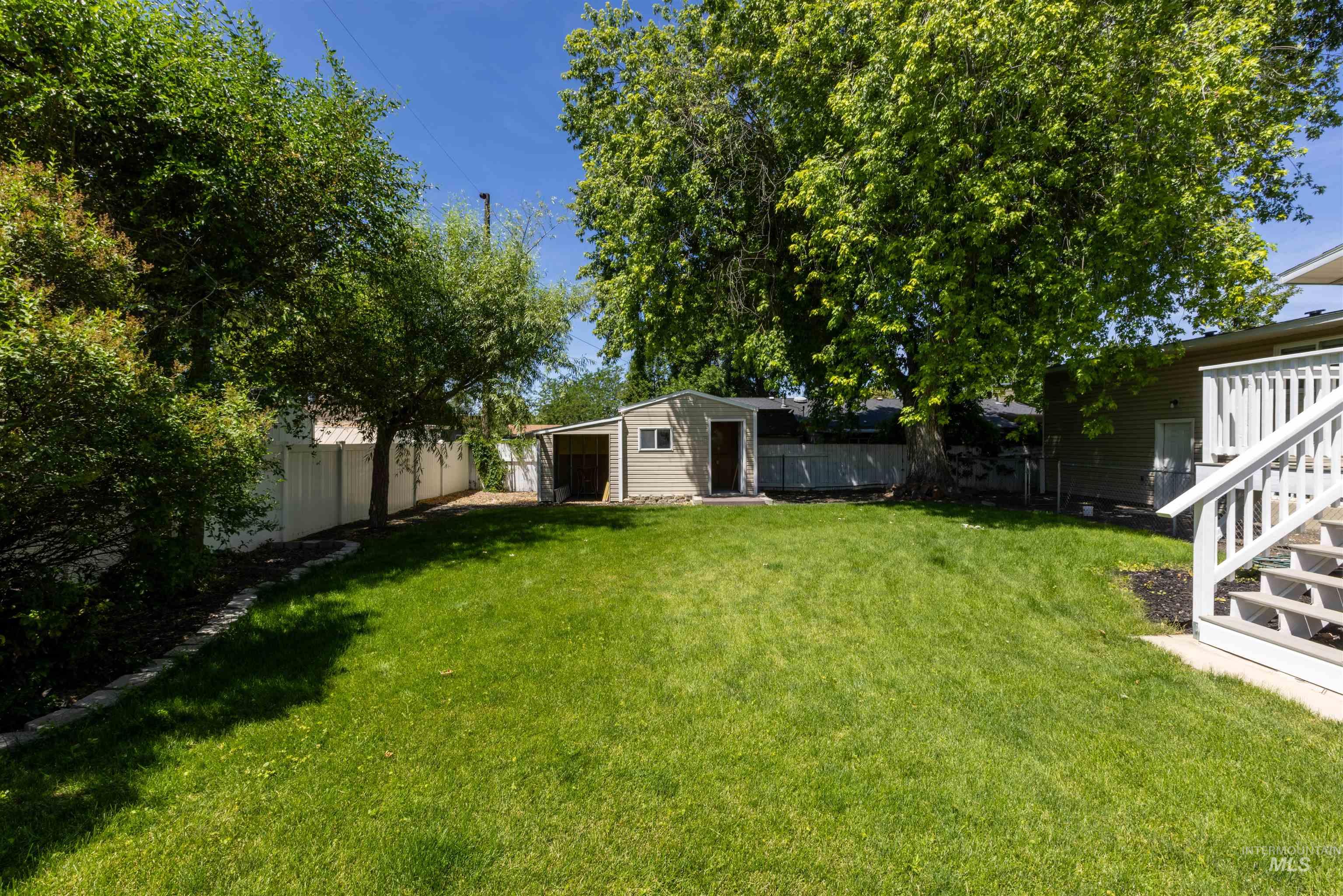 Fenced backyard with an outdoor structure