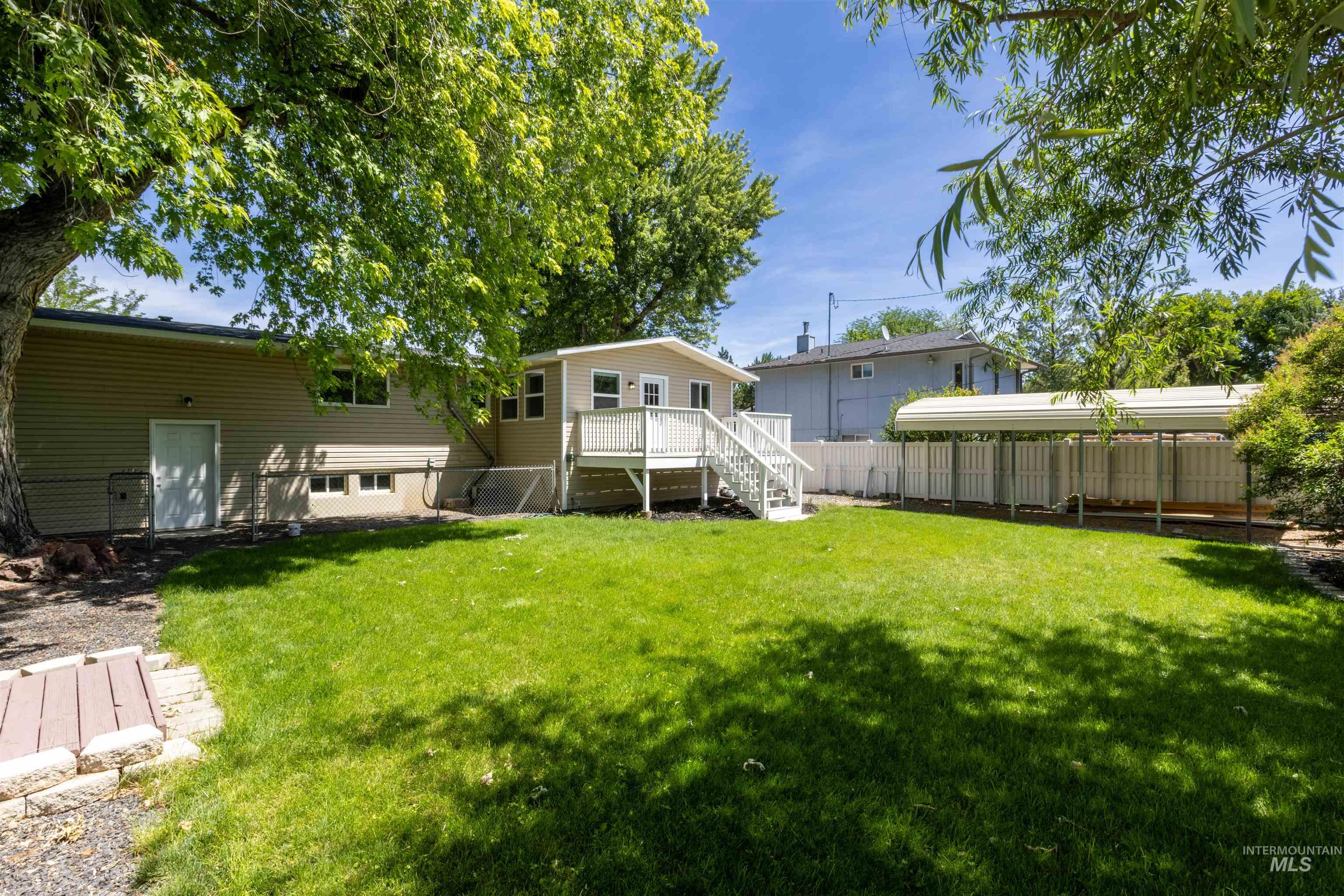 Fenced backyard with stairway and a deck
