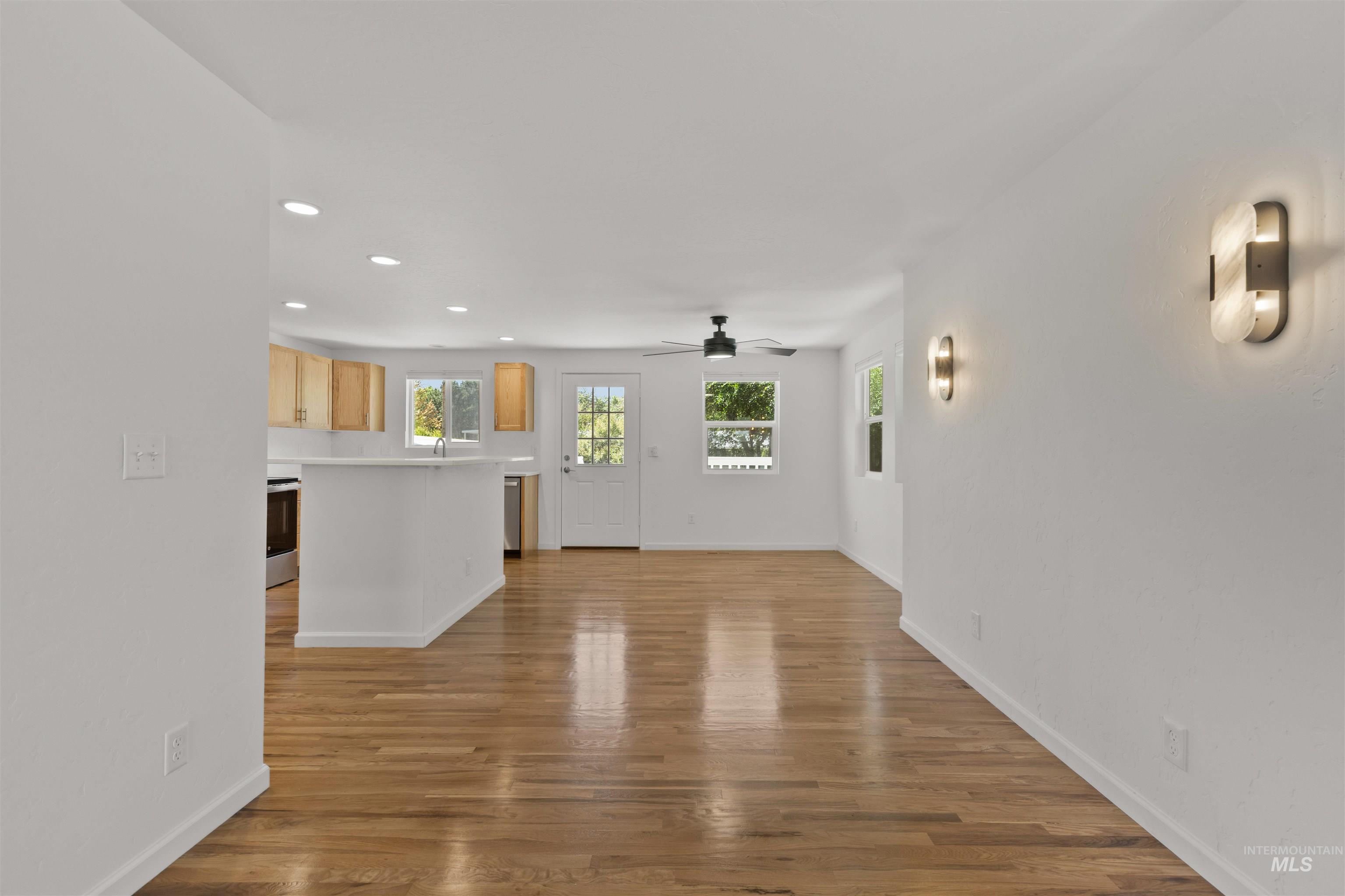 Unfurnished living room featuring recessed lighting, ceiling fan, and wood finished floors