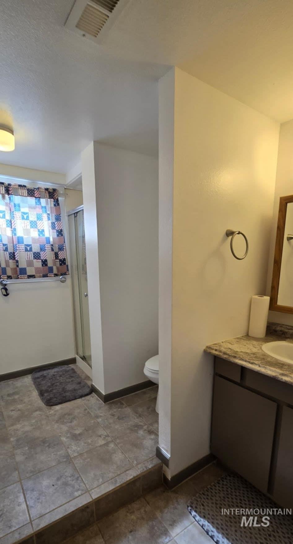 Bathroom featuring vanity and a shower stall