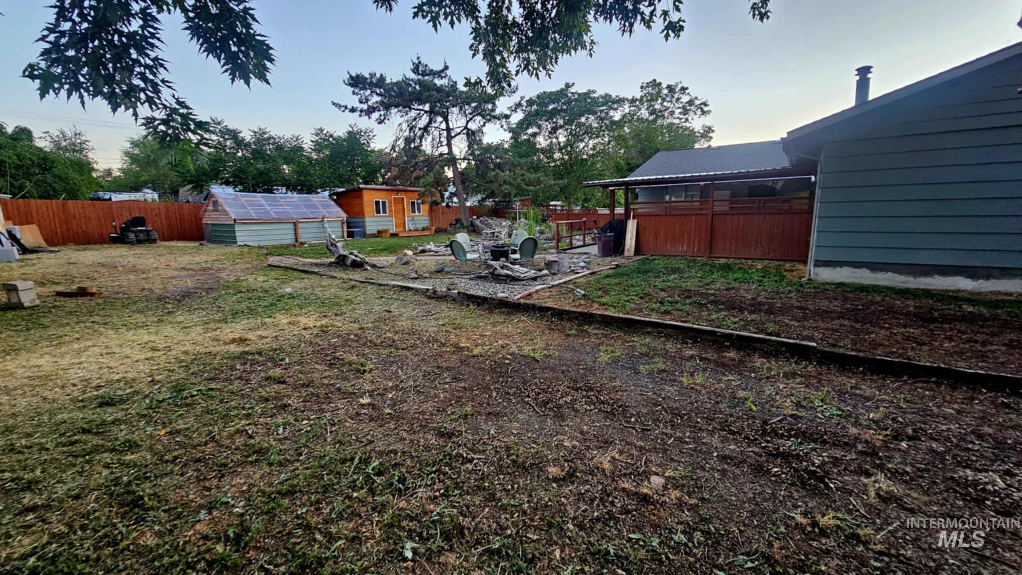 Spacious backyard with room for parking and/or a shop.   Several existing outbuildings.