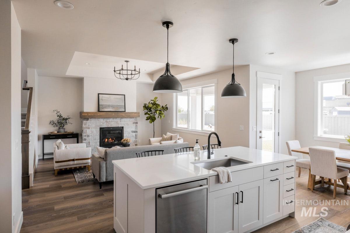 Kitchen with dishwasher, dark wood-style flooring, plenty of natural light, recessed lighting, and light countertops