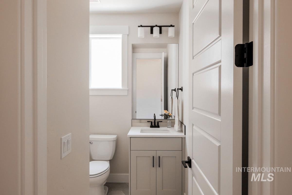 Half bathroom featuring vanity and toilet