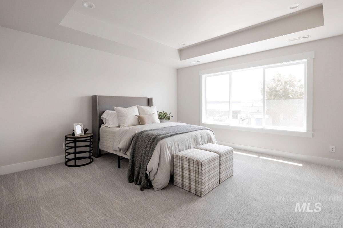 Bedroom featuring a tray ceiling, carpet flooring, and recessed lighting