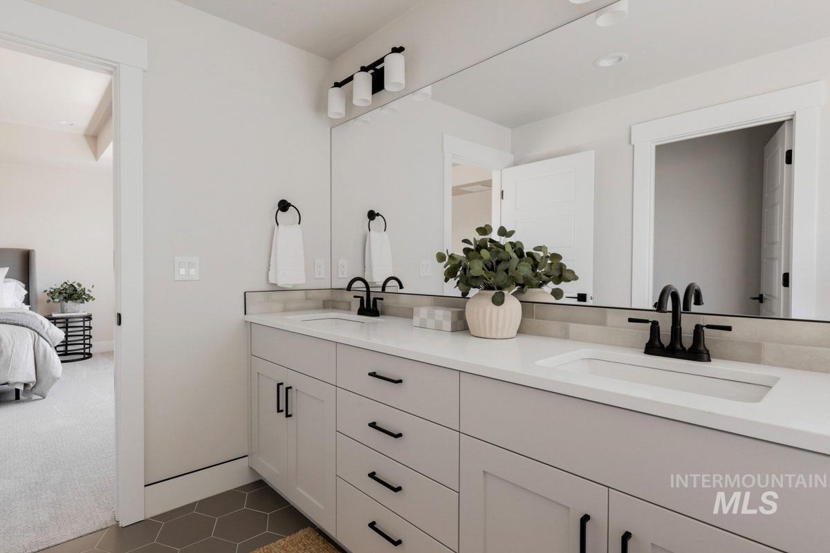 Full bath with double vanity, ensuite bath, and tile patterned floors