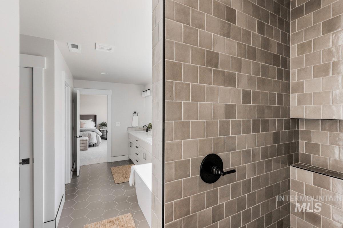 Ensuite bathroom with vanity and tile patterned flooring