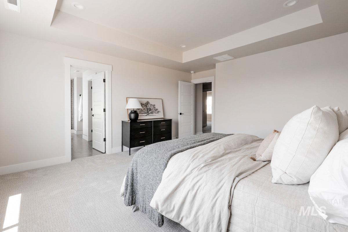 Bedroom featuring a raised ceiling, carpet flooring, and recessed lighting