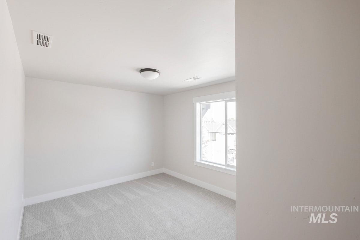 Spare room with light carpet and baseboards