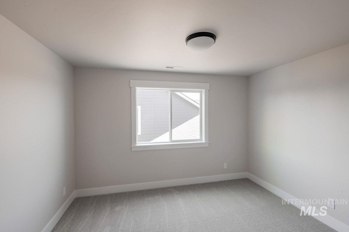 Spare room with light colored carpet and baseboards