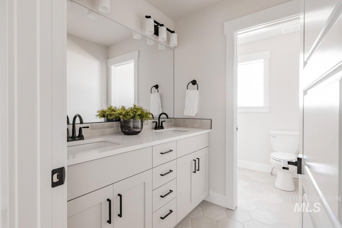 Bathroom with double vanity and tile patterned flooring