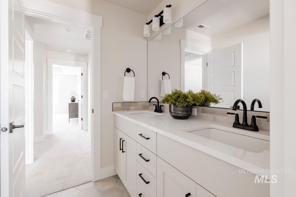 Bathroom with double vanity and tile patterned flooring