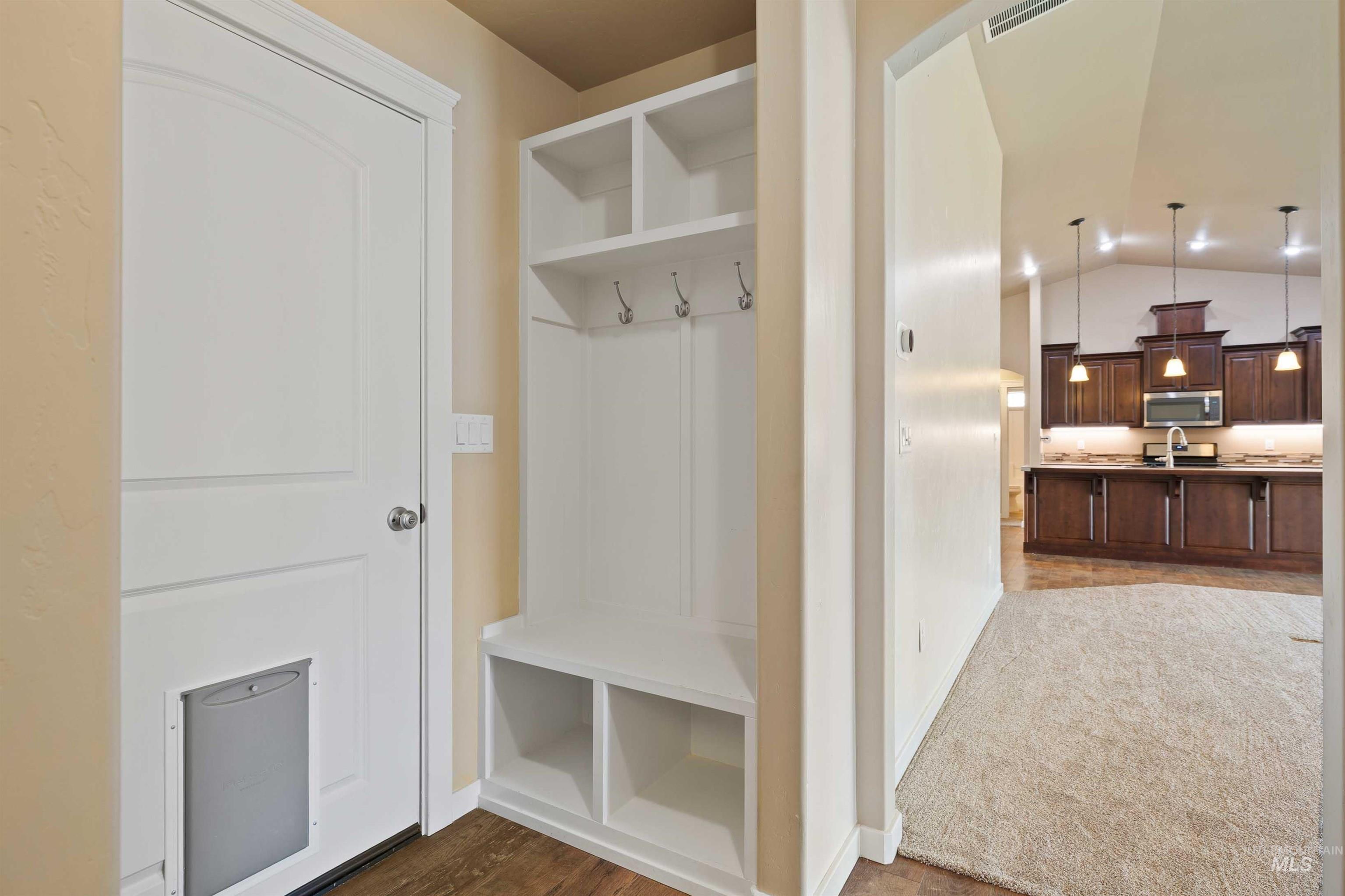 Mudroom with vaulted ceiling and dark wood finished floors