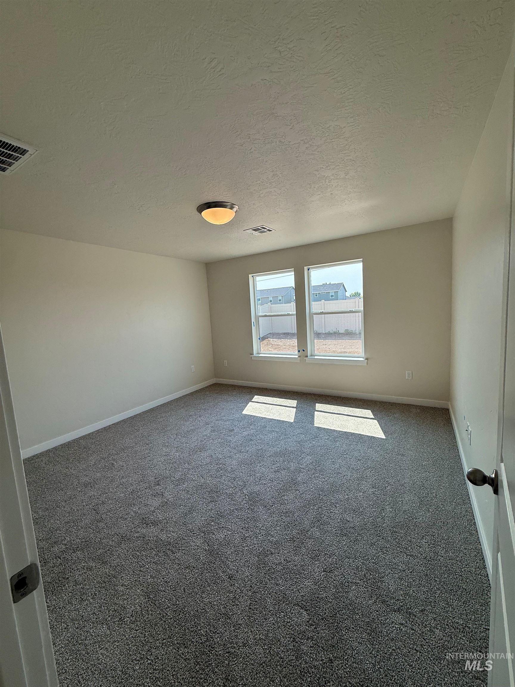 Unfurnished bedroom with carpet flooring and a textured ceiling