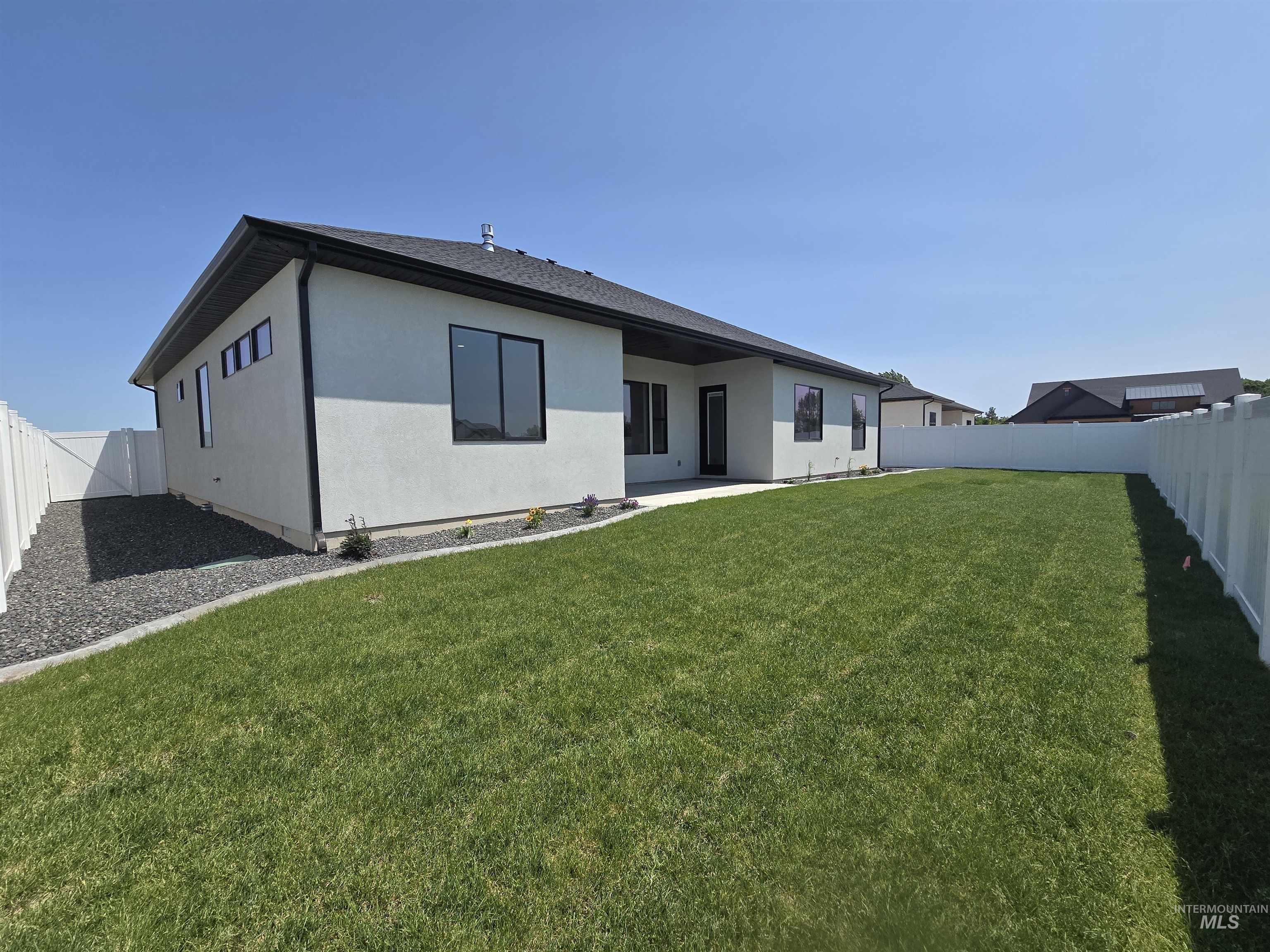Rear view of property featuring stucco siding and a fenced backyard