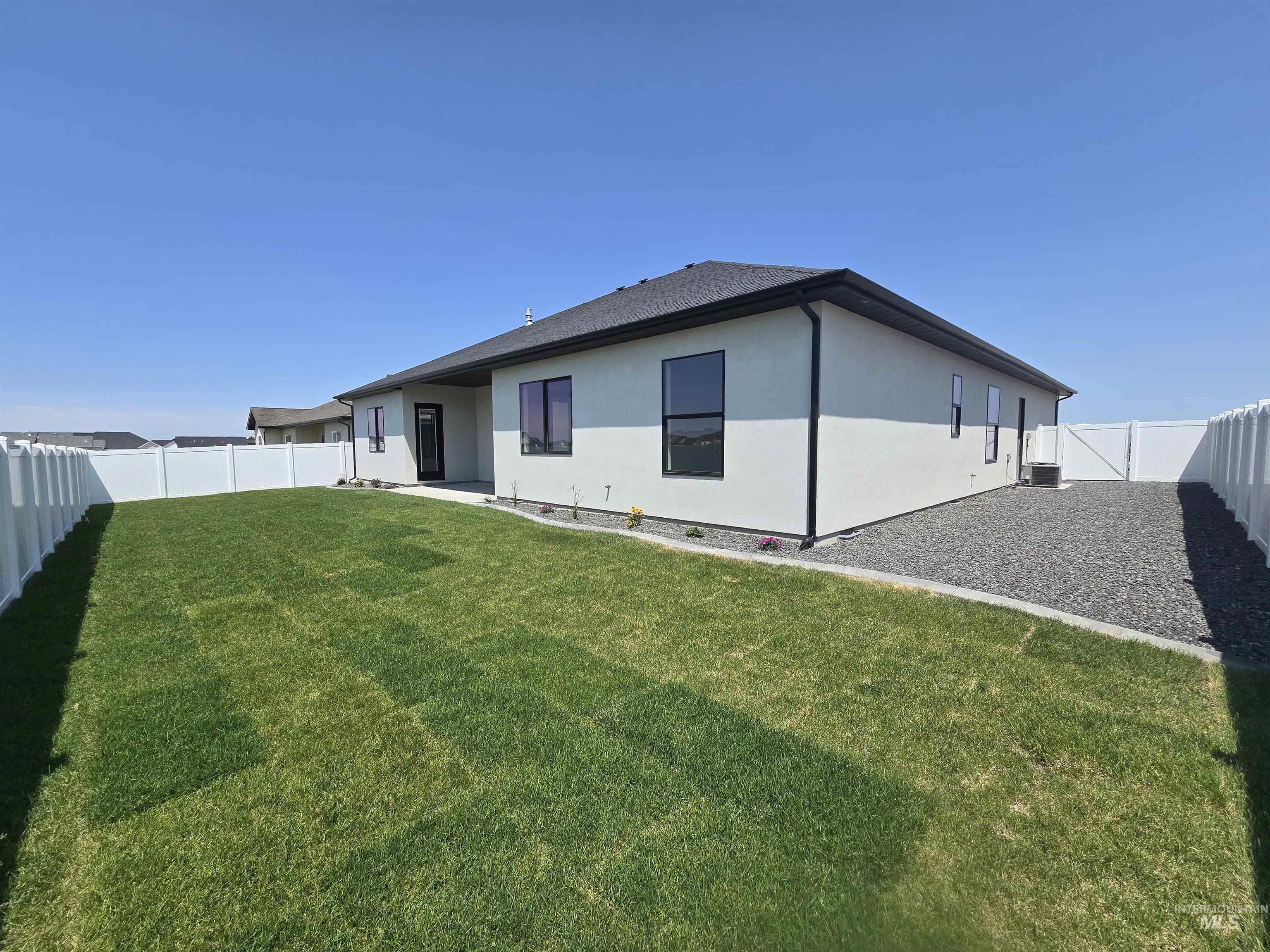 Back of property with a fenced backyard and stucco siding