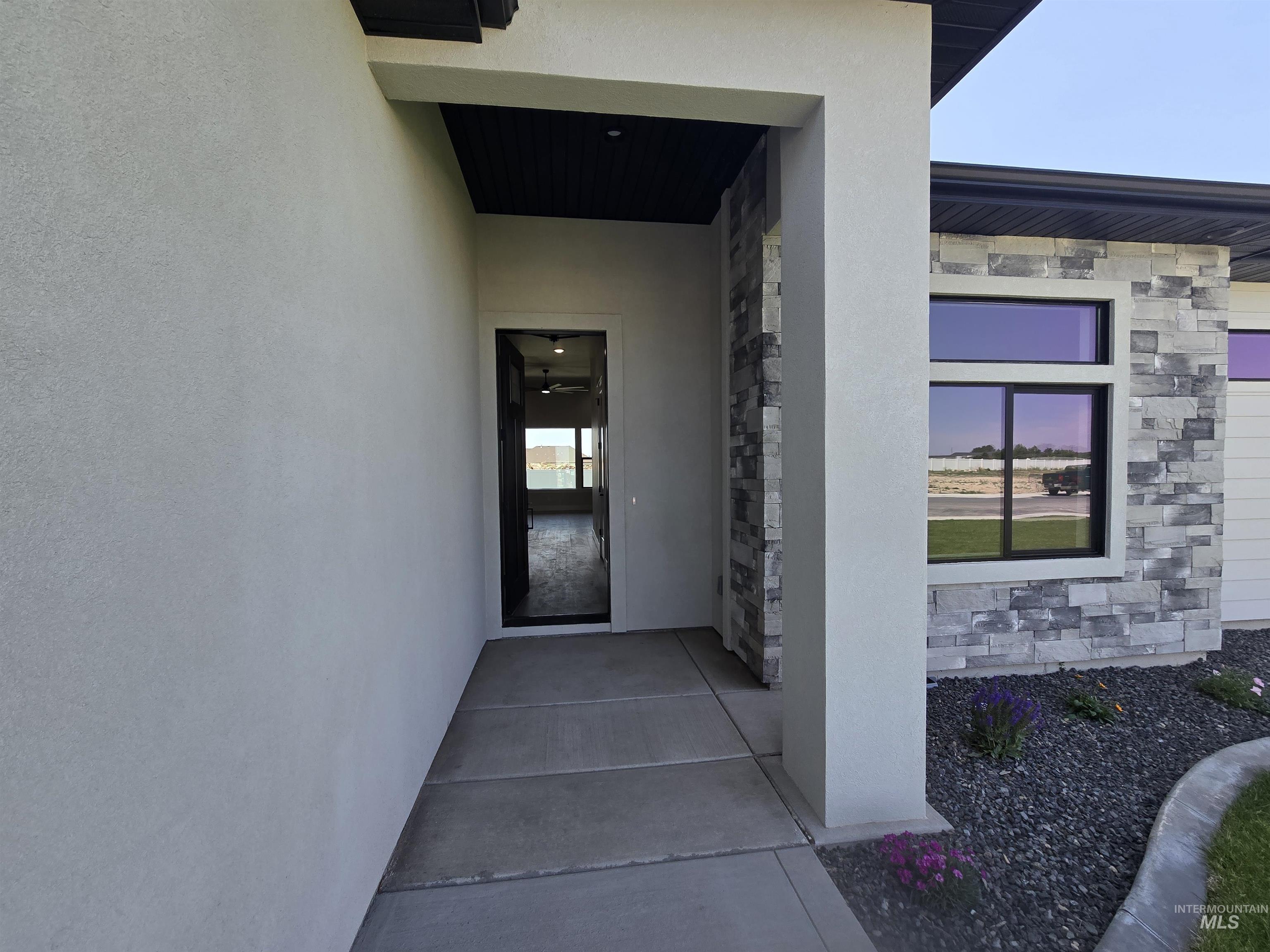 Property entrance with stone siding and stucco siding