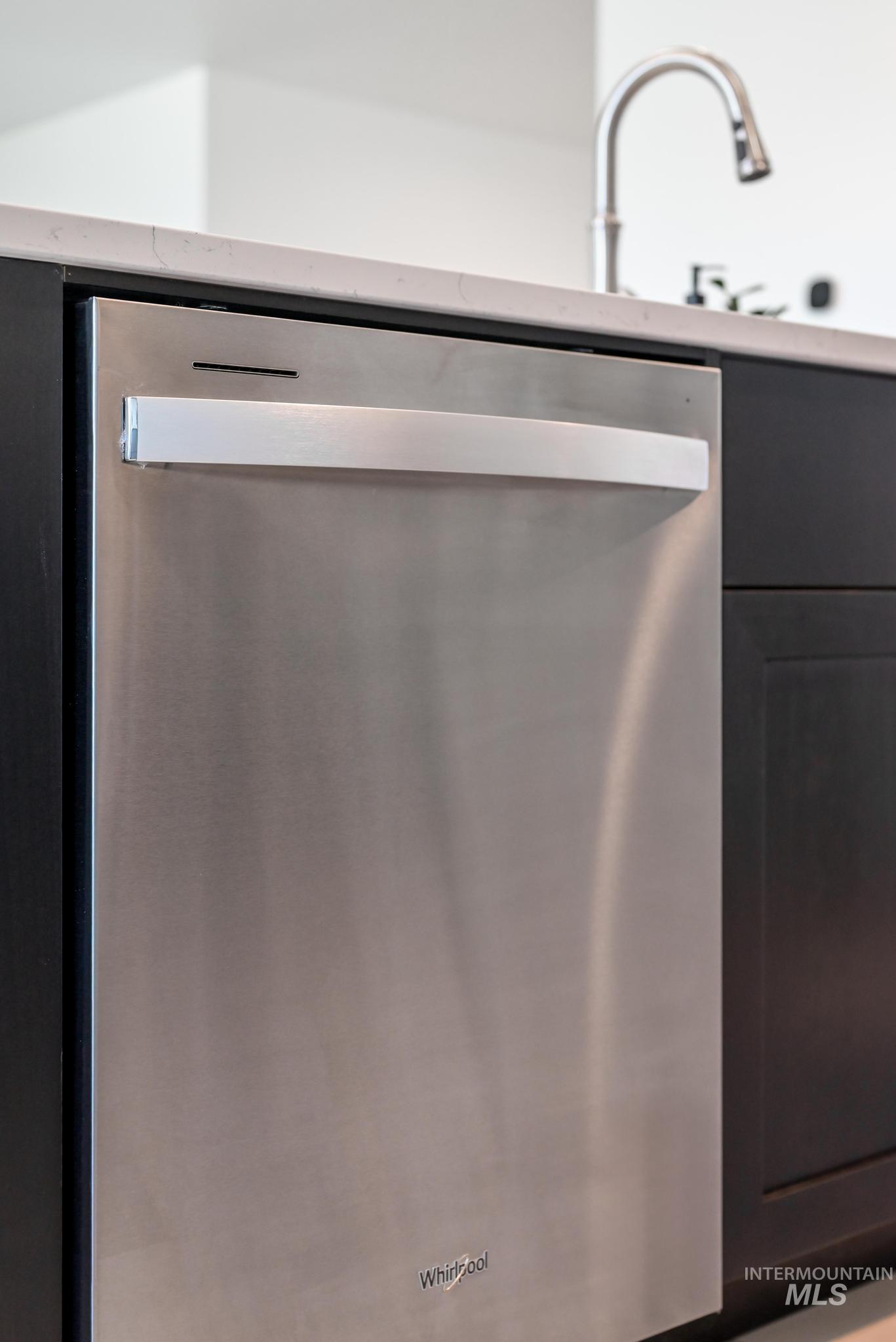 Kitchen view of stainless steel dishwasher and a sink