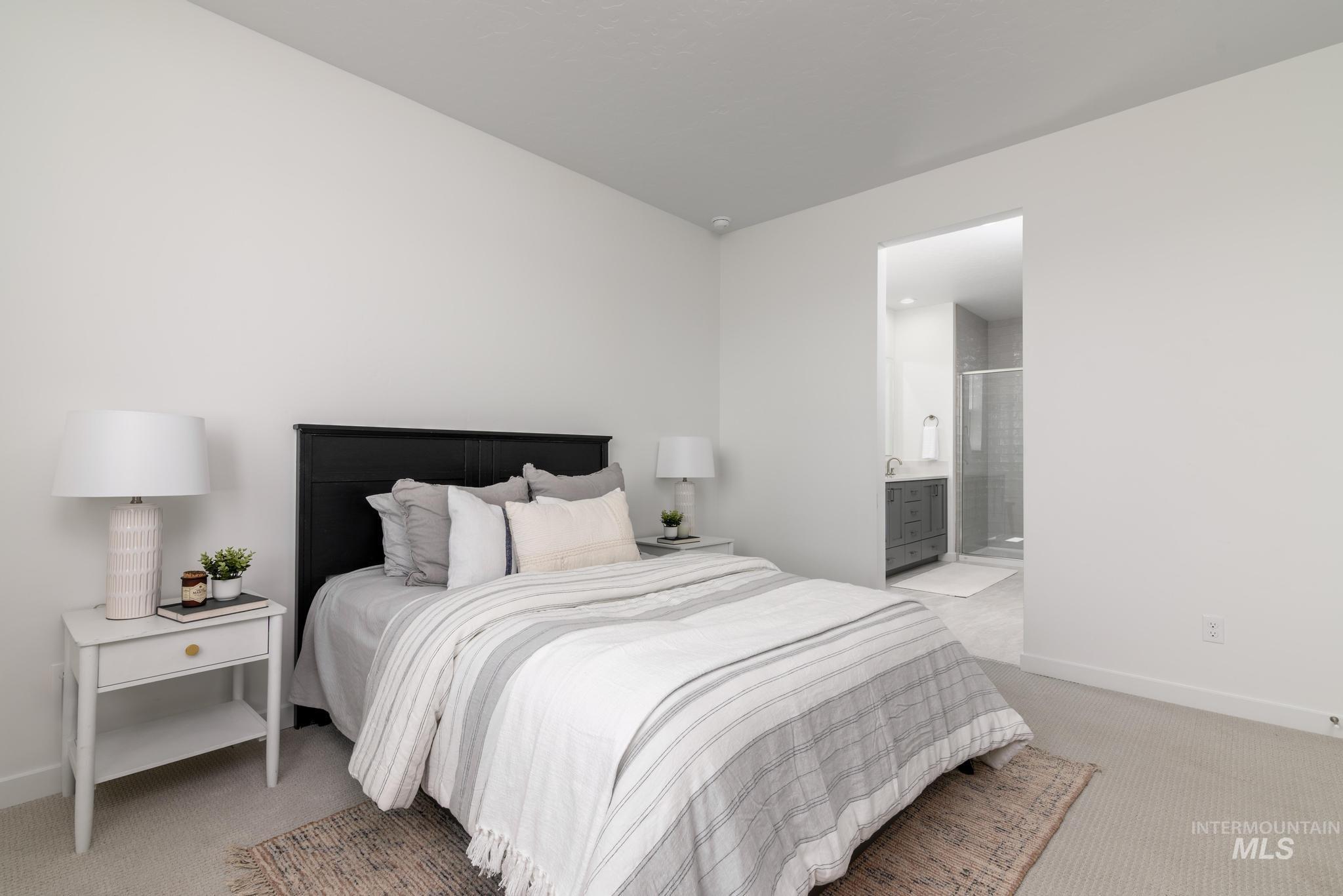 Bedroom with light colored carpet and connected bathroom