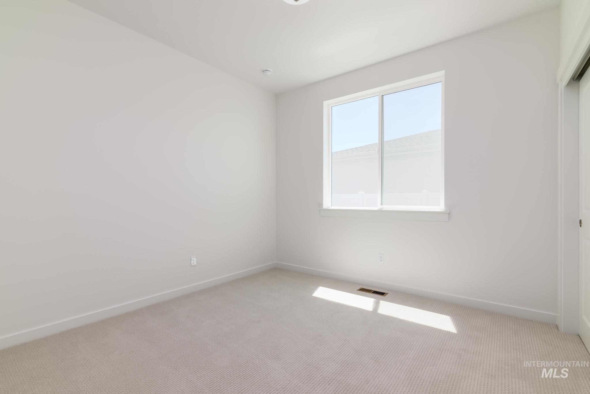 Unfurnished bedroom with light colored carpet and a closet