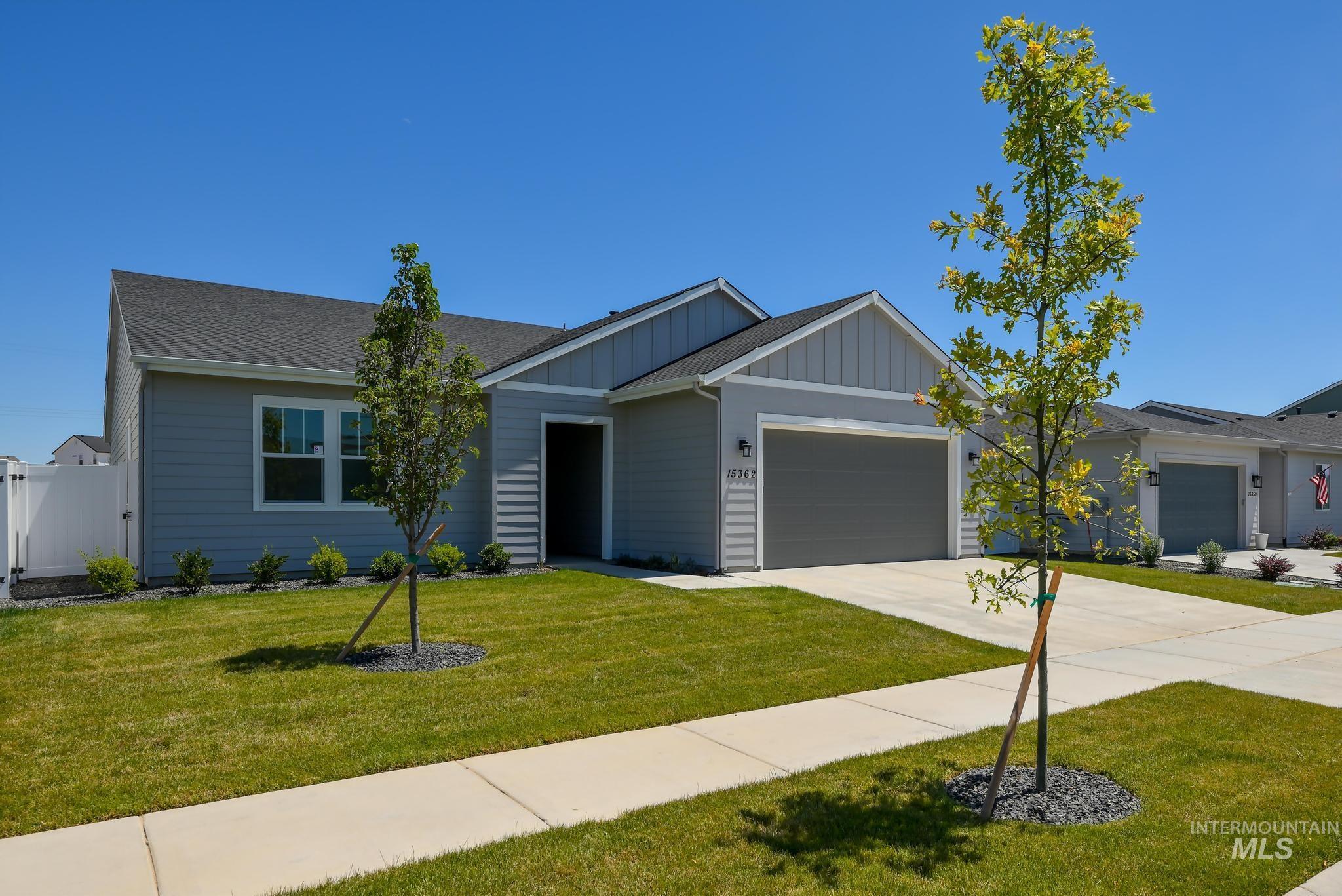 View of front of home featuring board and batten siding, an attached garage, and driveway