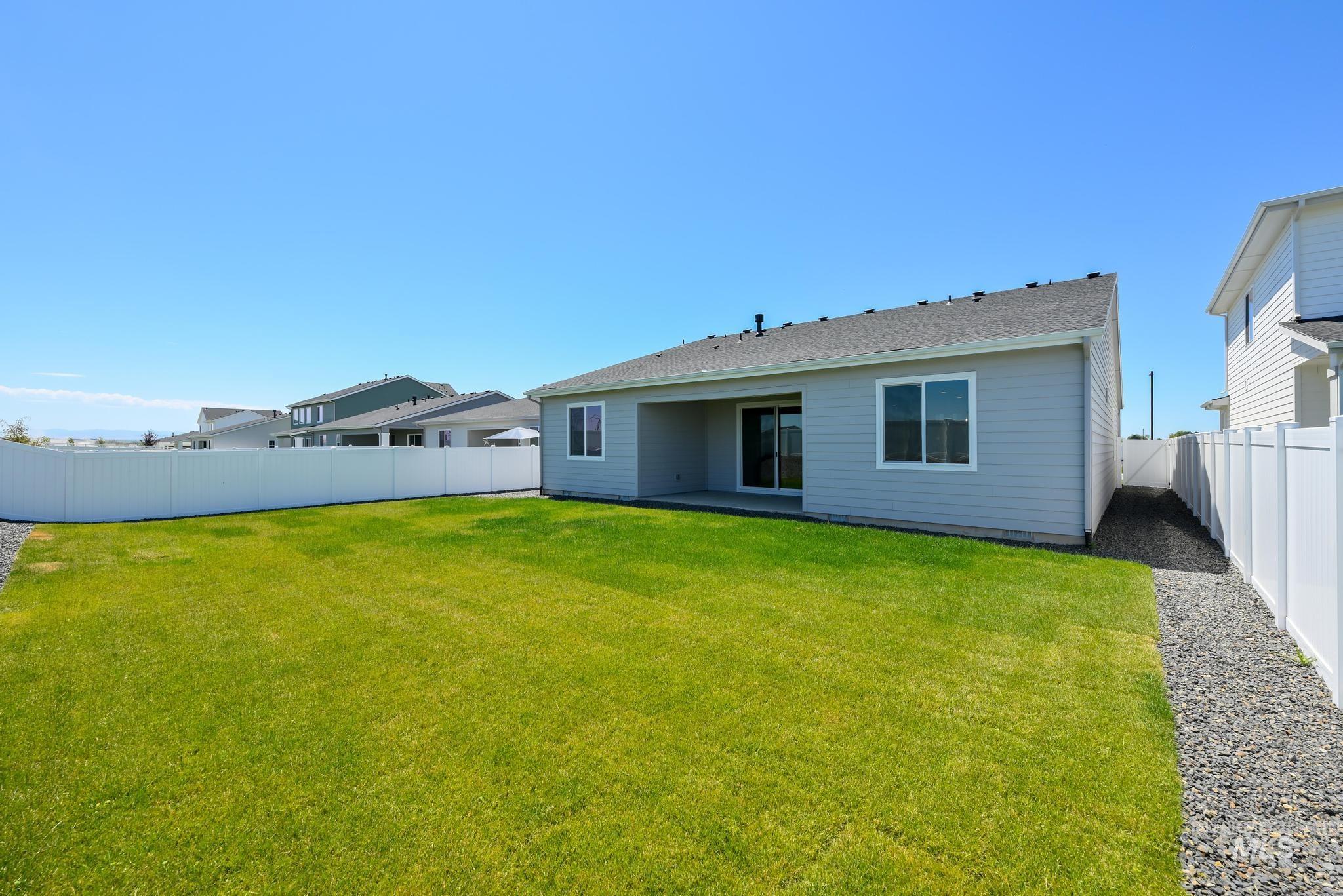 Rear view of property featuring a fenced backyard and a shingled roof