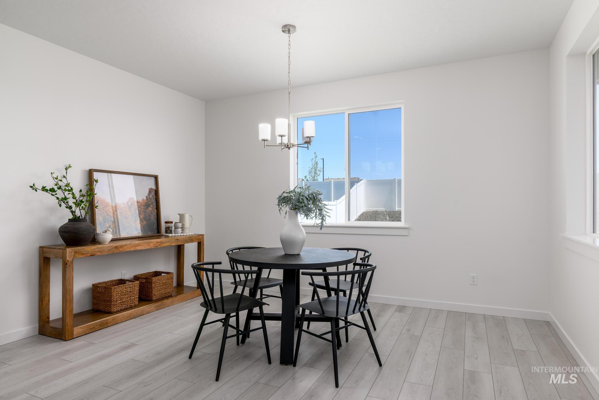 Dining room with light wood-type flooring and a chandelier