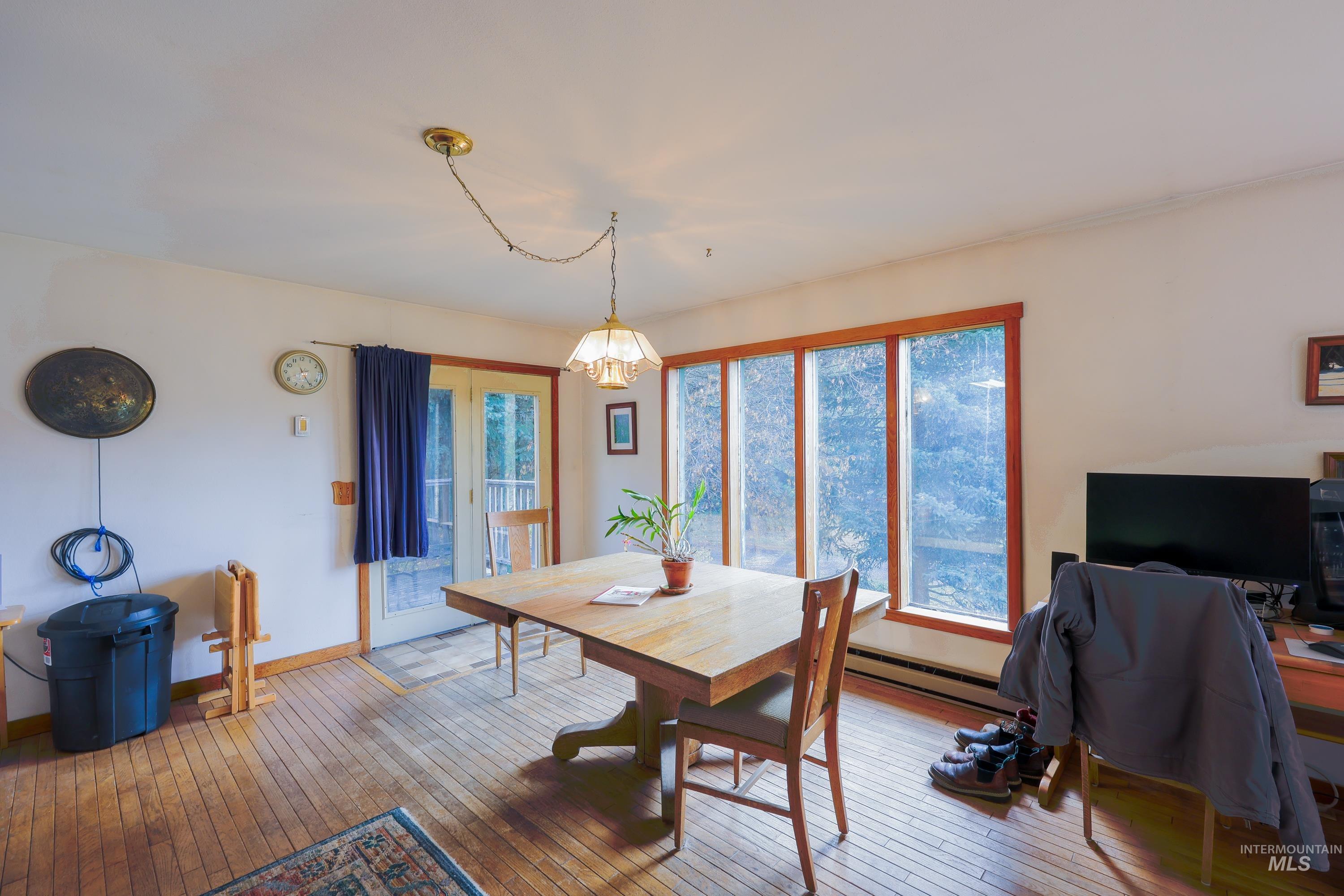 Dining space featuring hardwood / wood-style floors, healthy amount of natural light, and baseboard heating