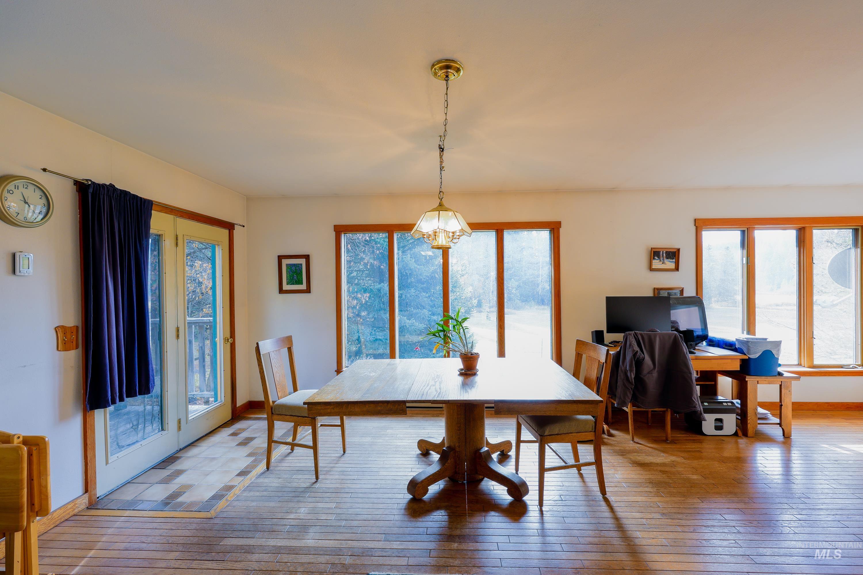 Dining room with light wood-style flooring and healthy amount of natural light