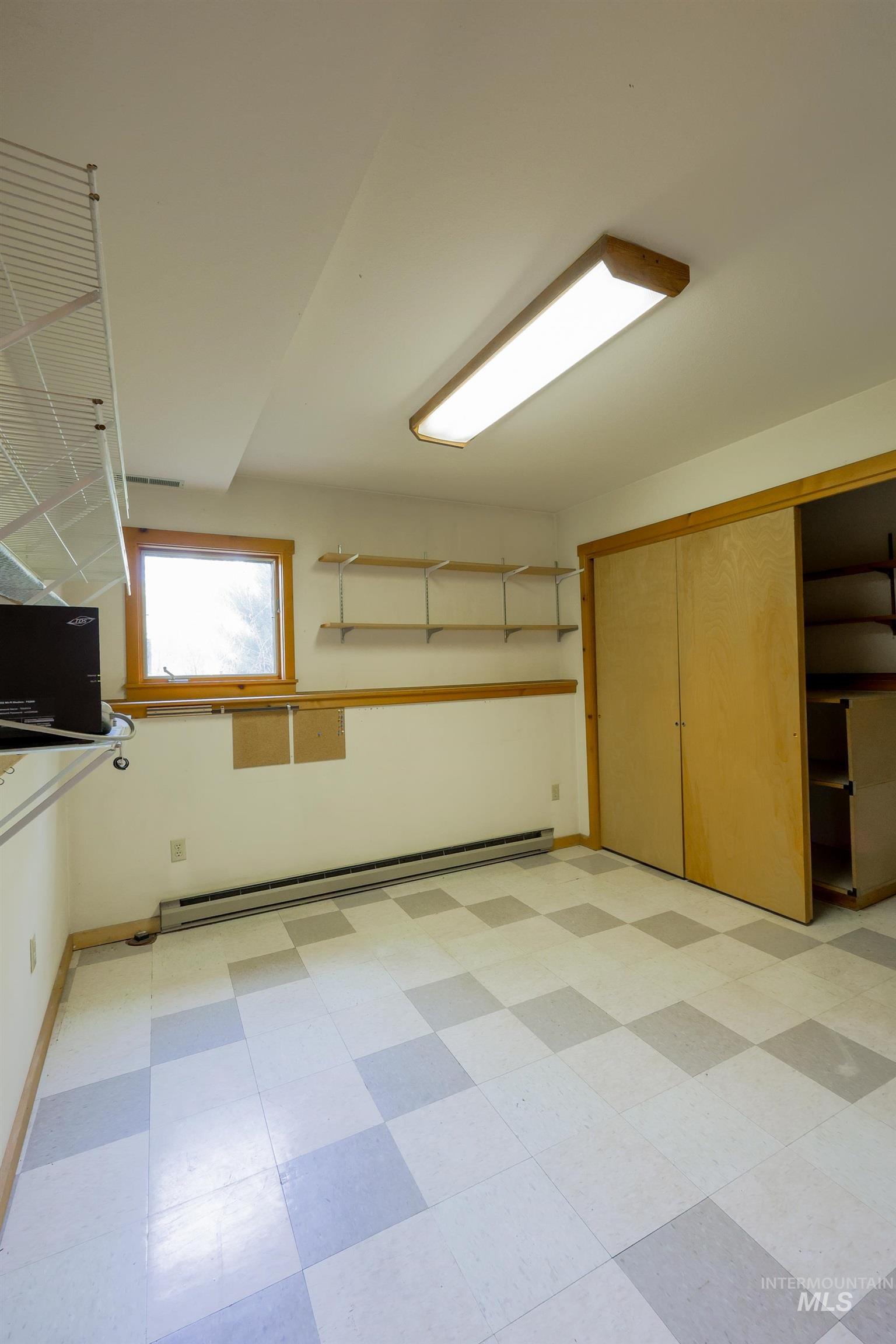 Interior space with light floors and a baseboard heating unit