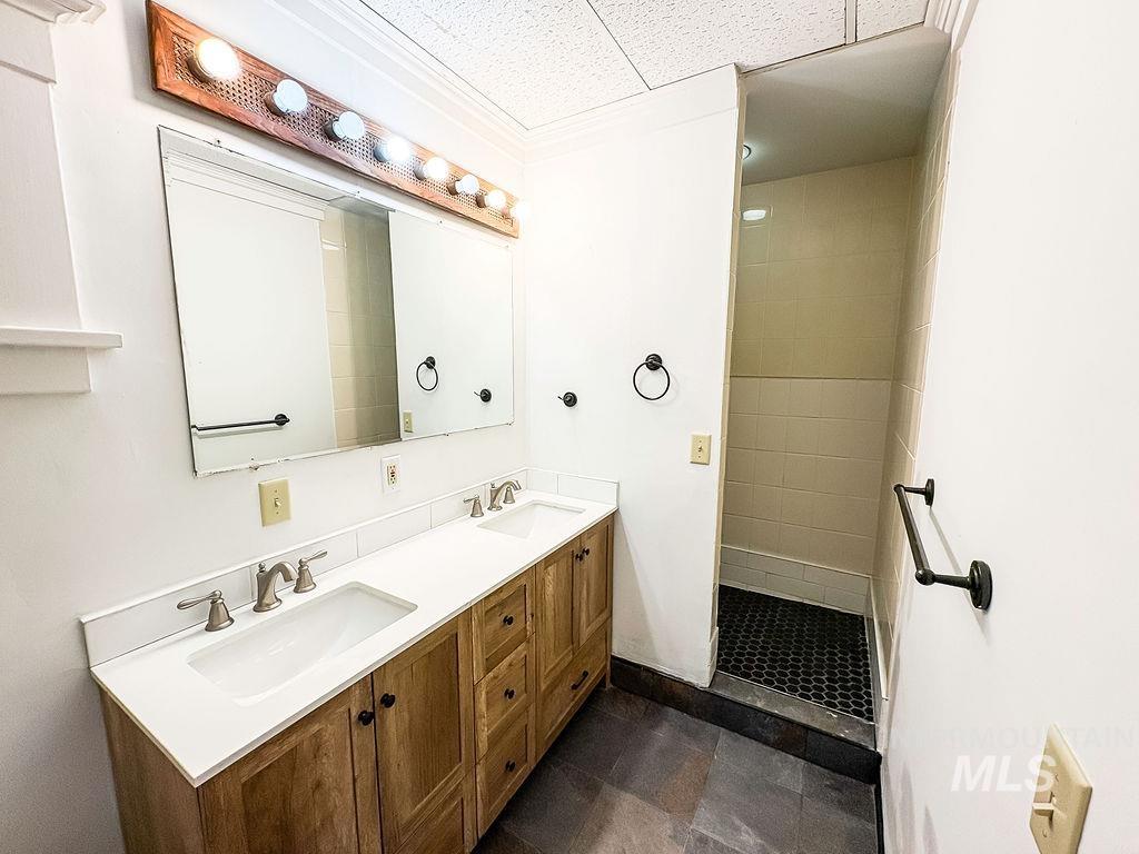 Bathroom featuring double vanity and a tile shower