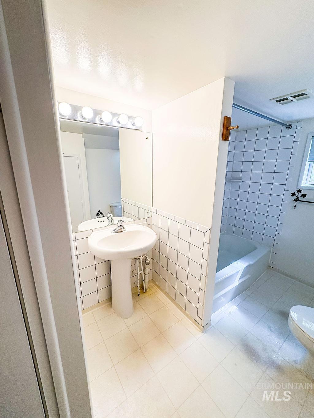 Bathroom featuring tile walls and tile patterned flooring