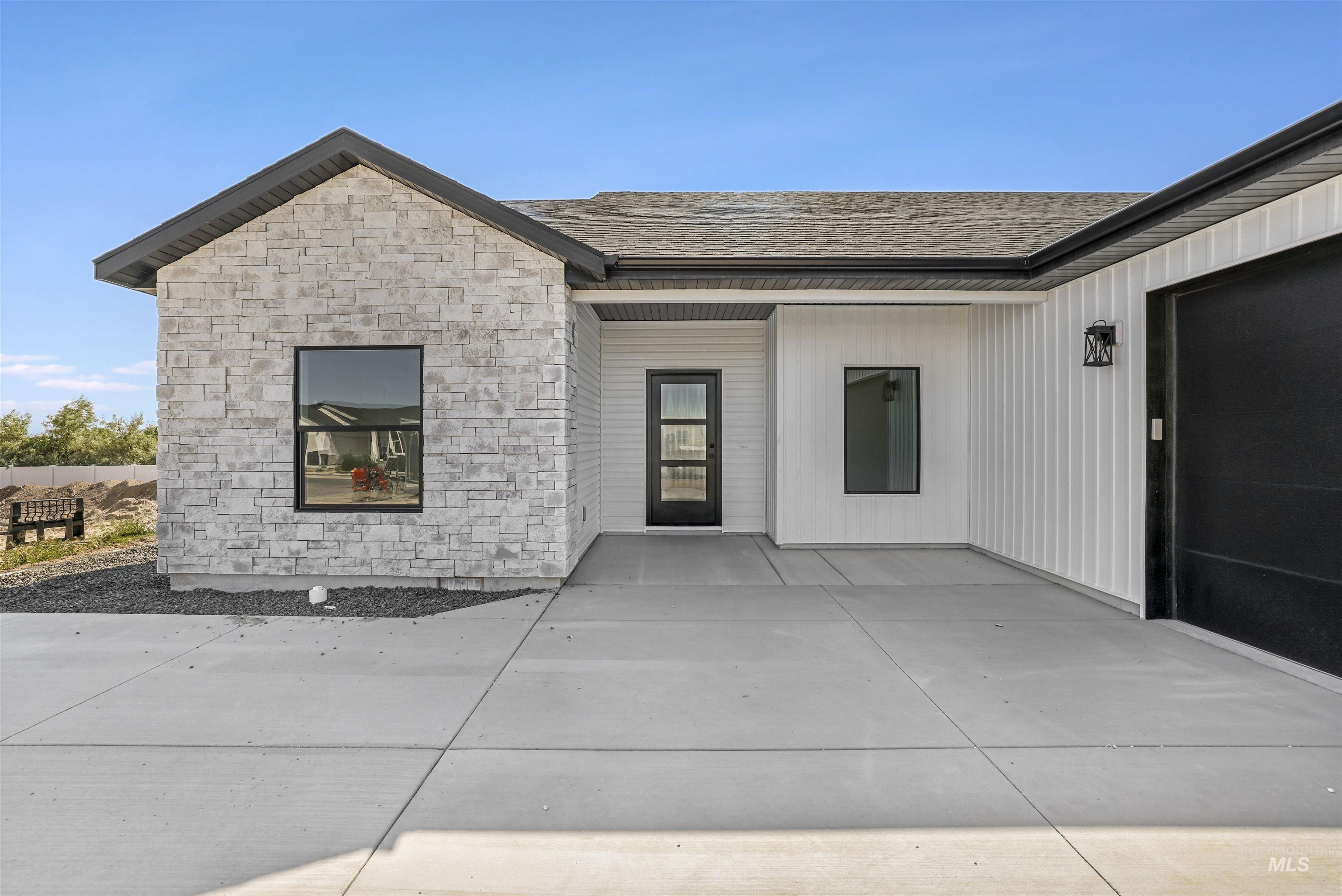 Doorway to property featuring stone siding and a patio area