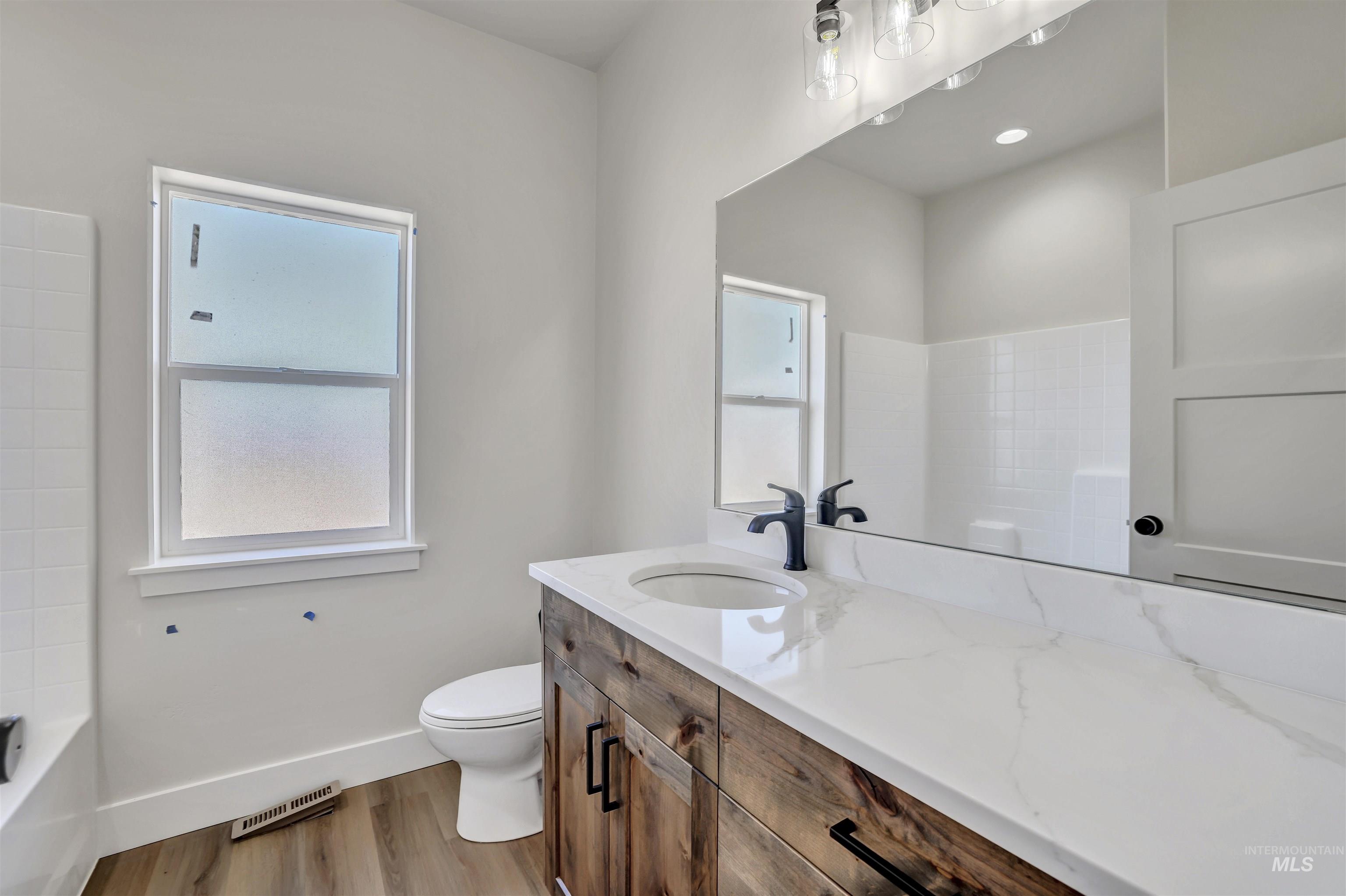 Full bathroom featuring vanity and wood finished floors