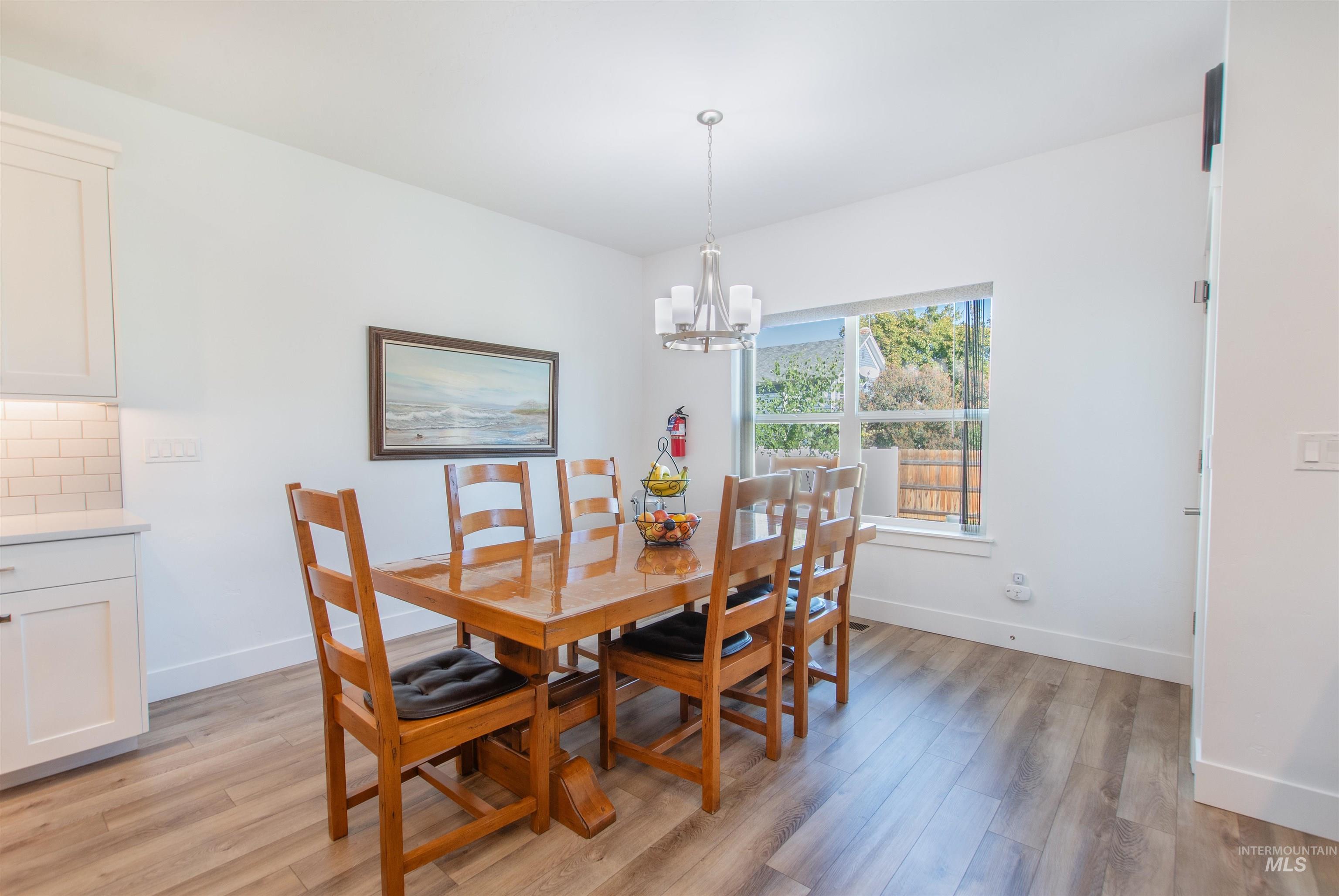 Dining room with light wood finished floors and a chandelier