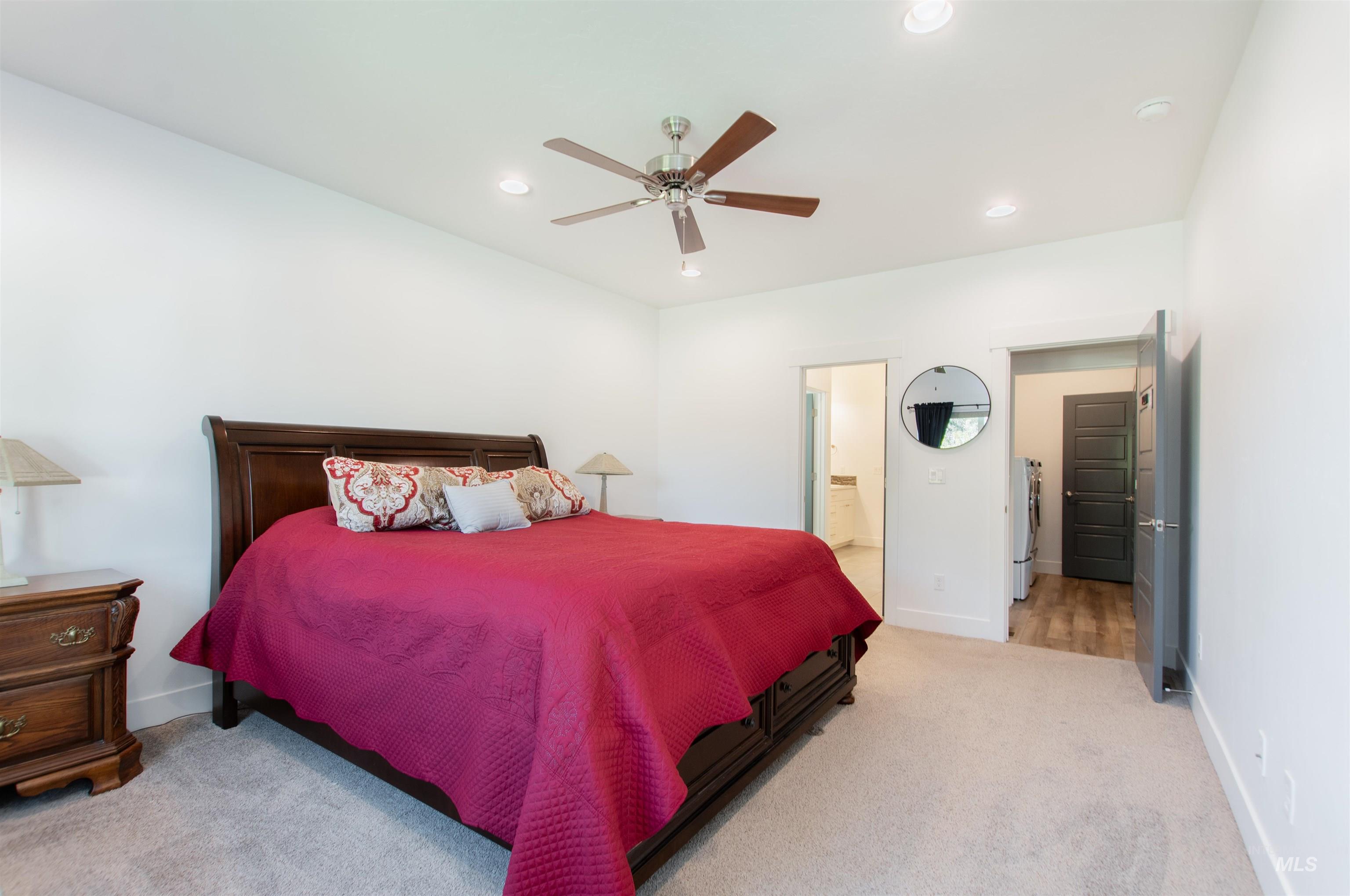 Bedroom featuring light colored carpet, recessed lighting, a ceiling fan, and connected bathroom