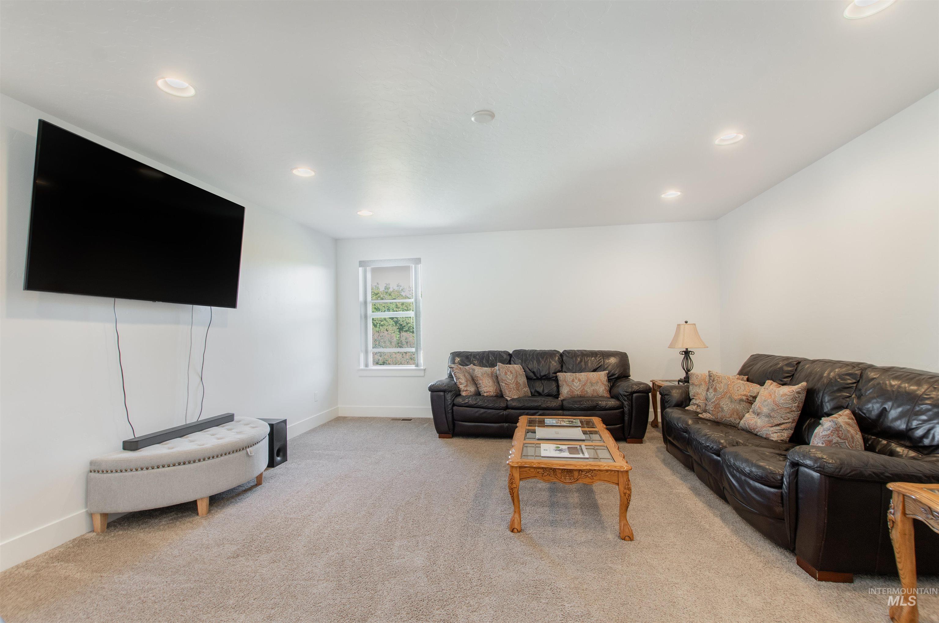 Carpeted living area featuring baseboards and recessed lighting