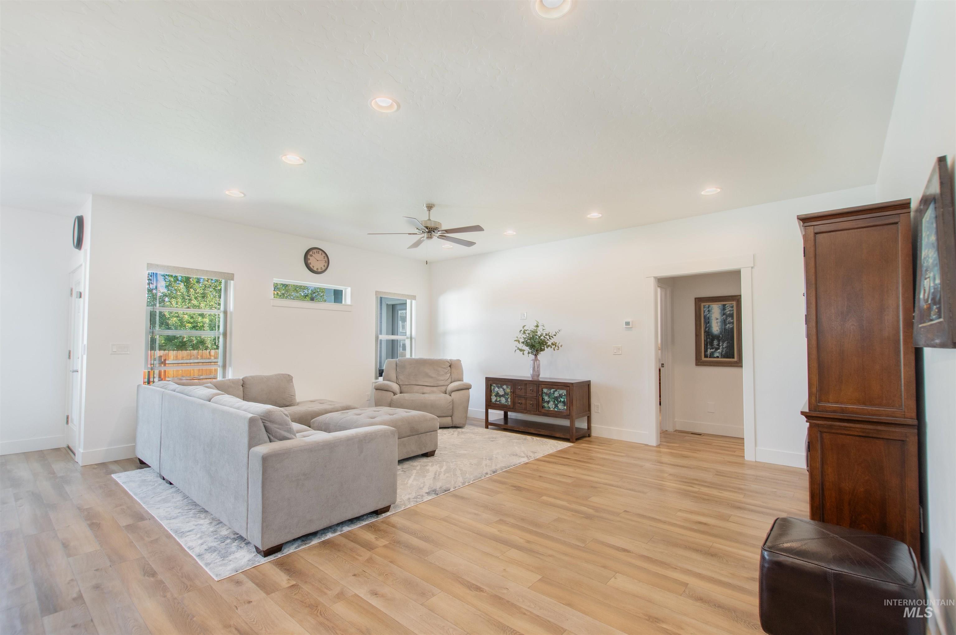 Living area featuring recessed lighting, light wood-style flooring, and a ceiling fan