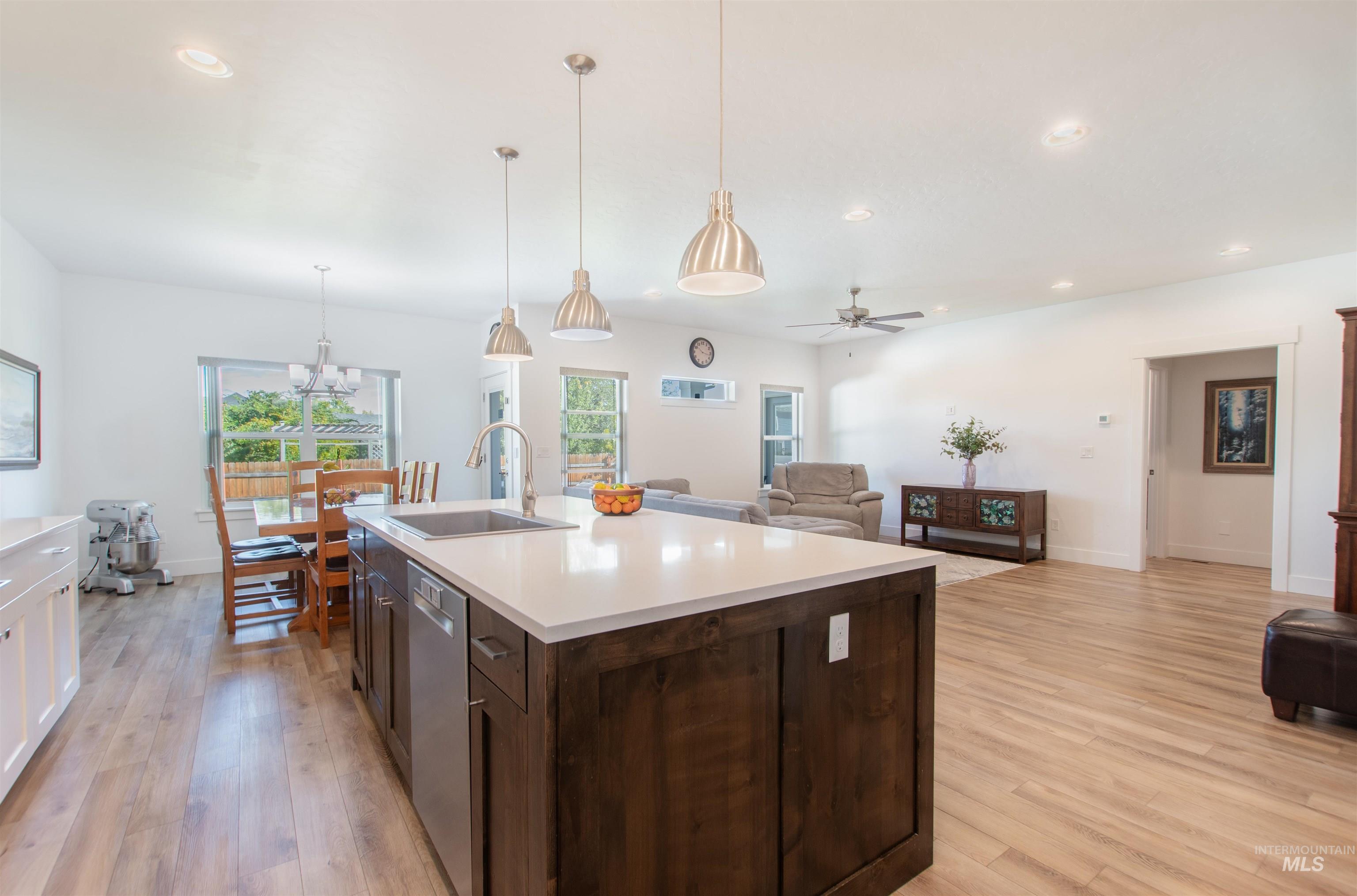 Kitchen featuring dark brown cabinetry, open floor plan, decorative light fixtures, recessed lighting, and ceiling fan