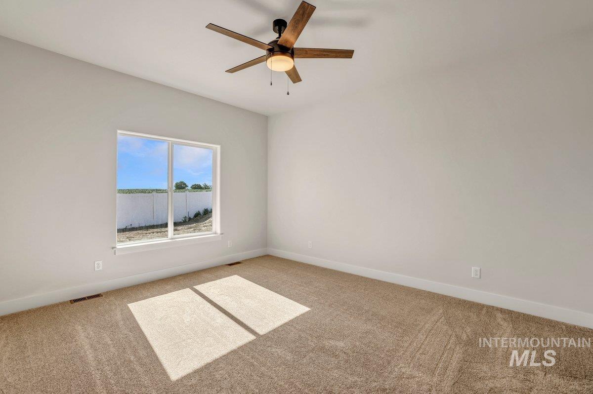 Empty room with light carpet and ceiling fan
