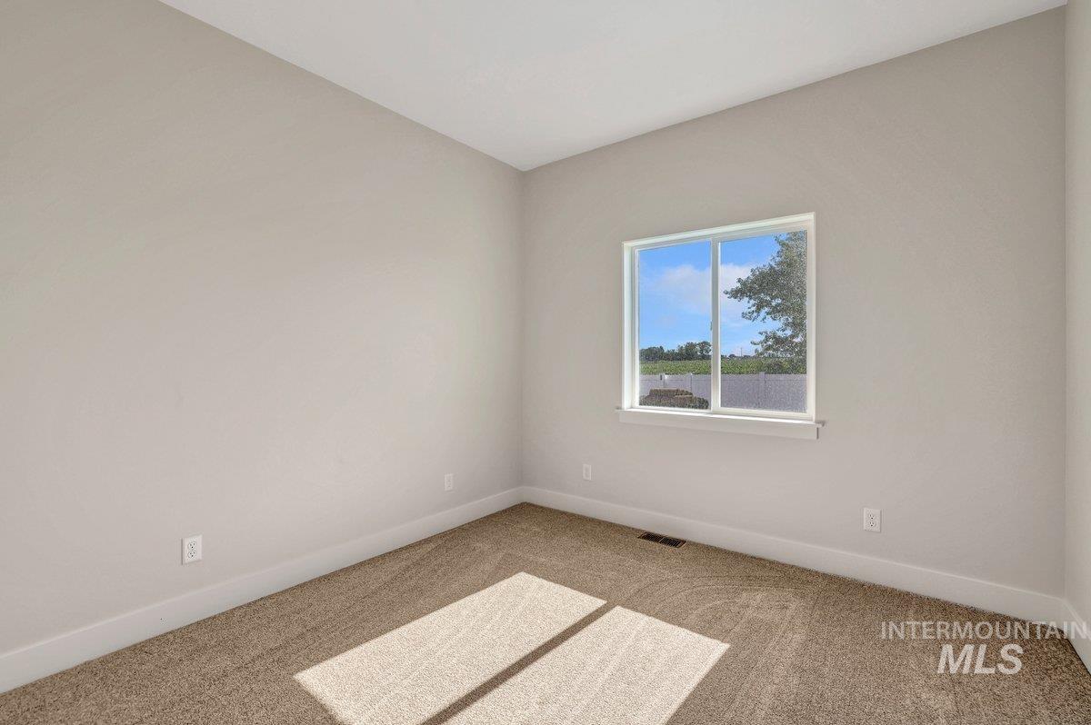 Empty room with carpet and baseboards