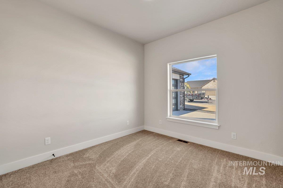 Empty room featuring carpet and baseboards