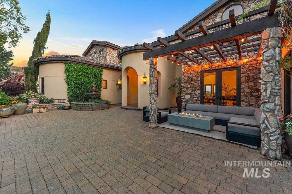 Patio terrace at dusk with a patio, an outdoor living space with a fire pit, a pergola, and french doors