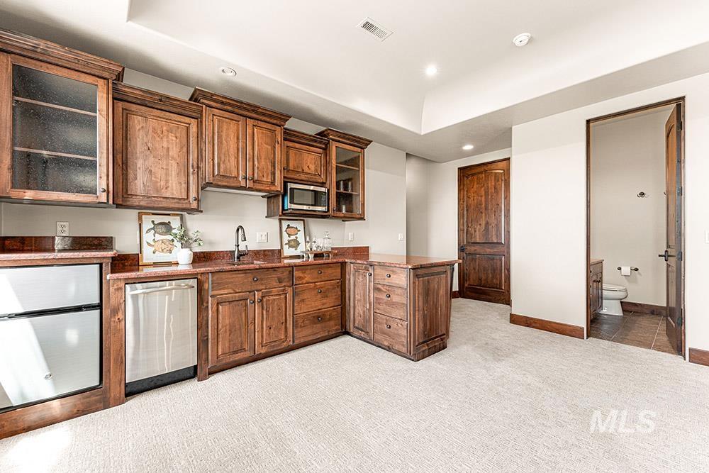 Kitchen with recessed lighting, a peninsula, light colored carpet, stainless steel appliances, and glass insert cabinets