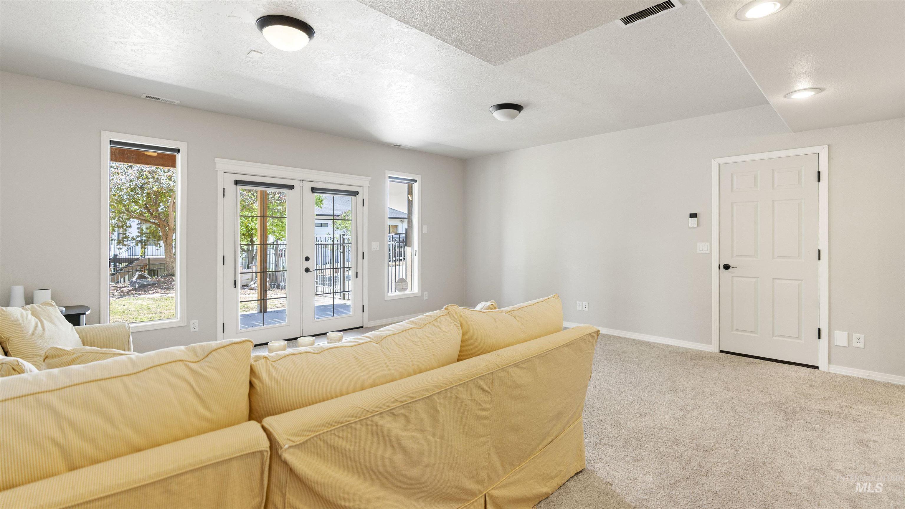 Living area featuring french doors, carpet, and recessed lighting