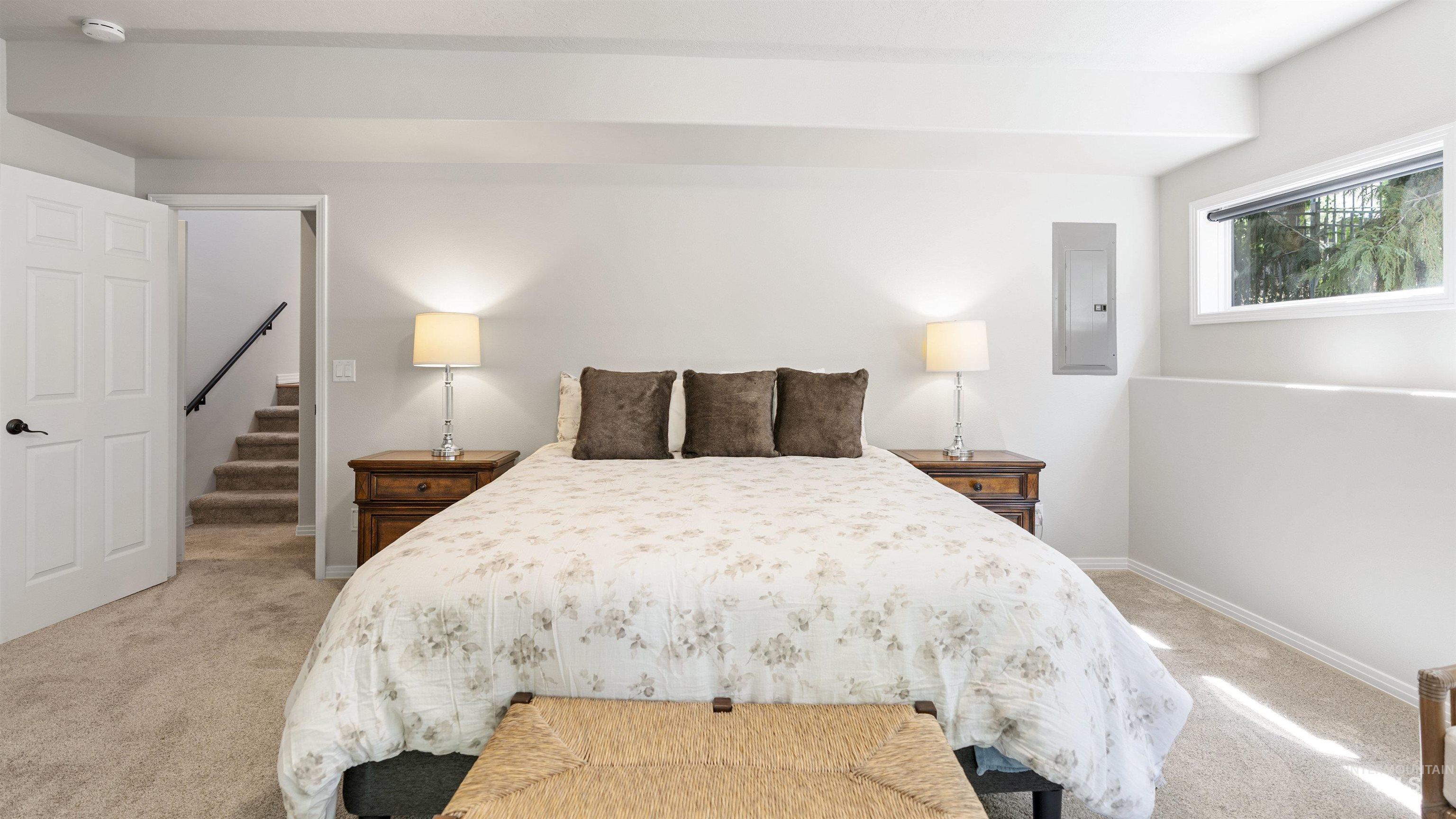 Bedroom featuring electric panel and light colored carpet