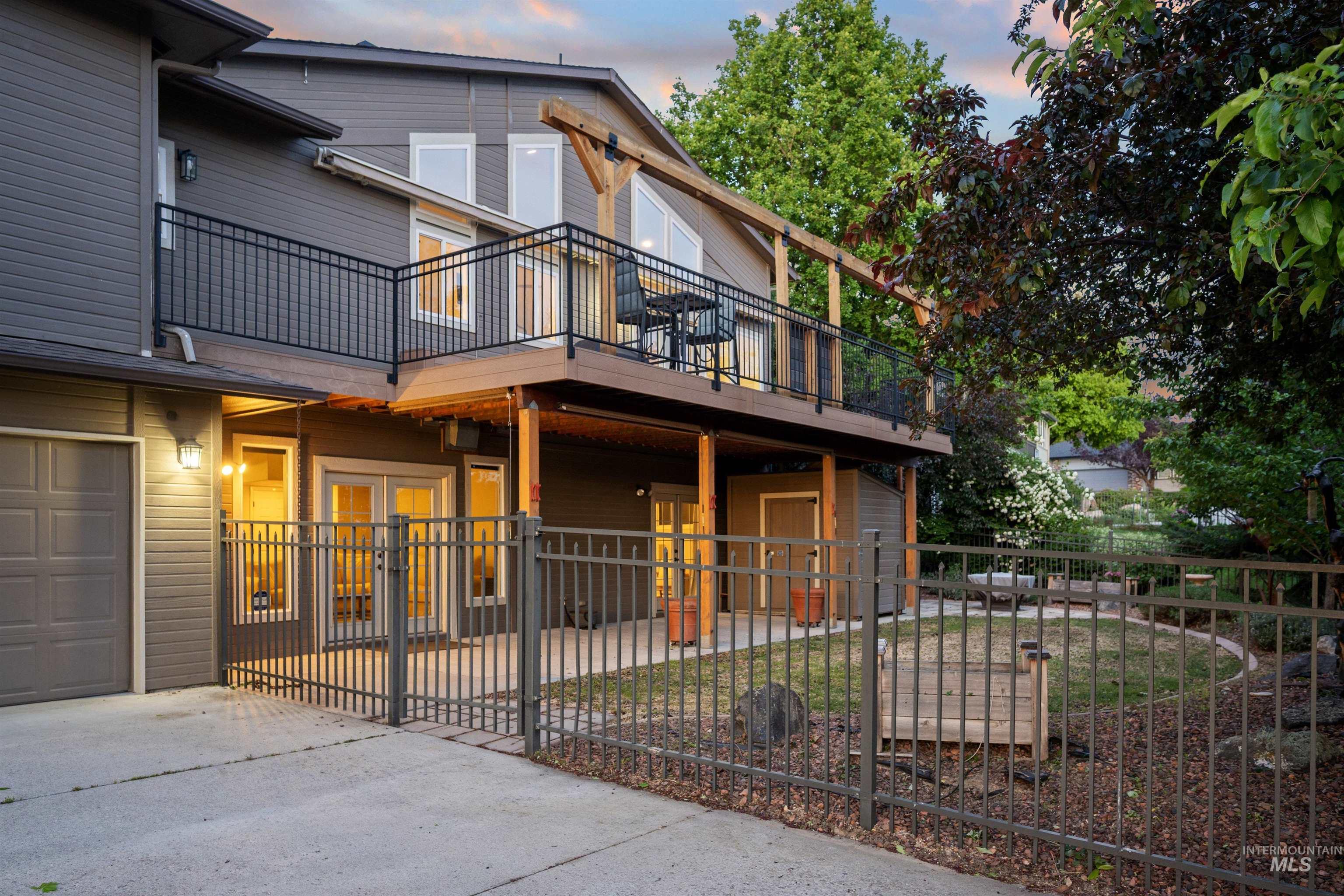 View of front of property with a balcony, concrete driveway, a garage, and french doors