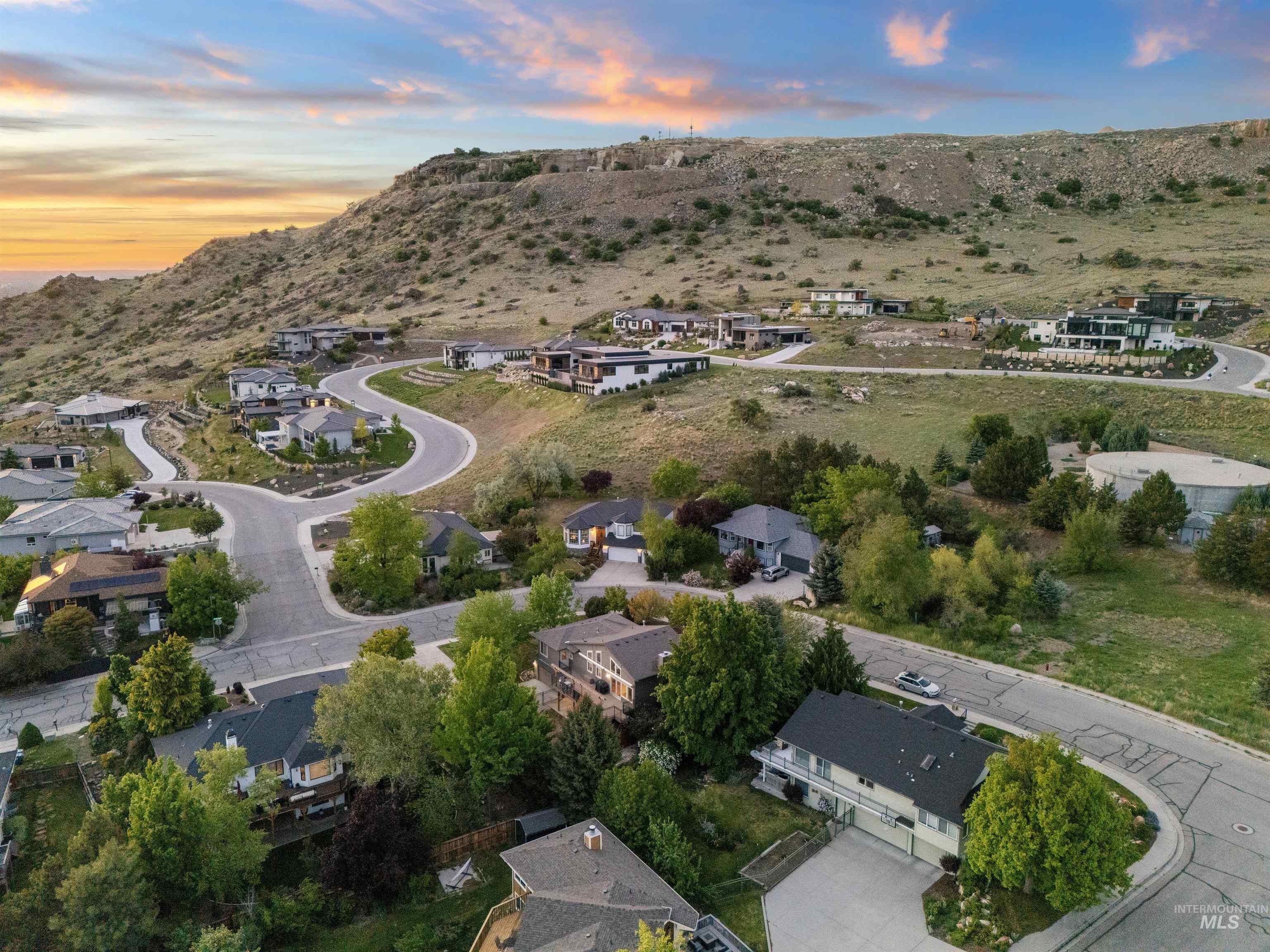 Aerial view of property and surrounding area featuring mountains and nearby suburban area